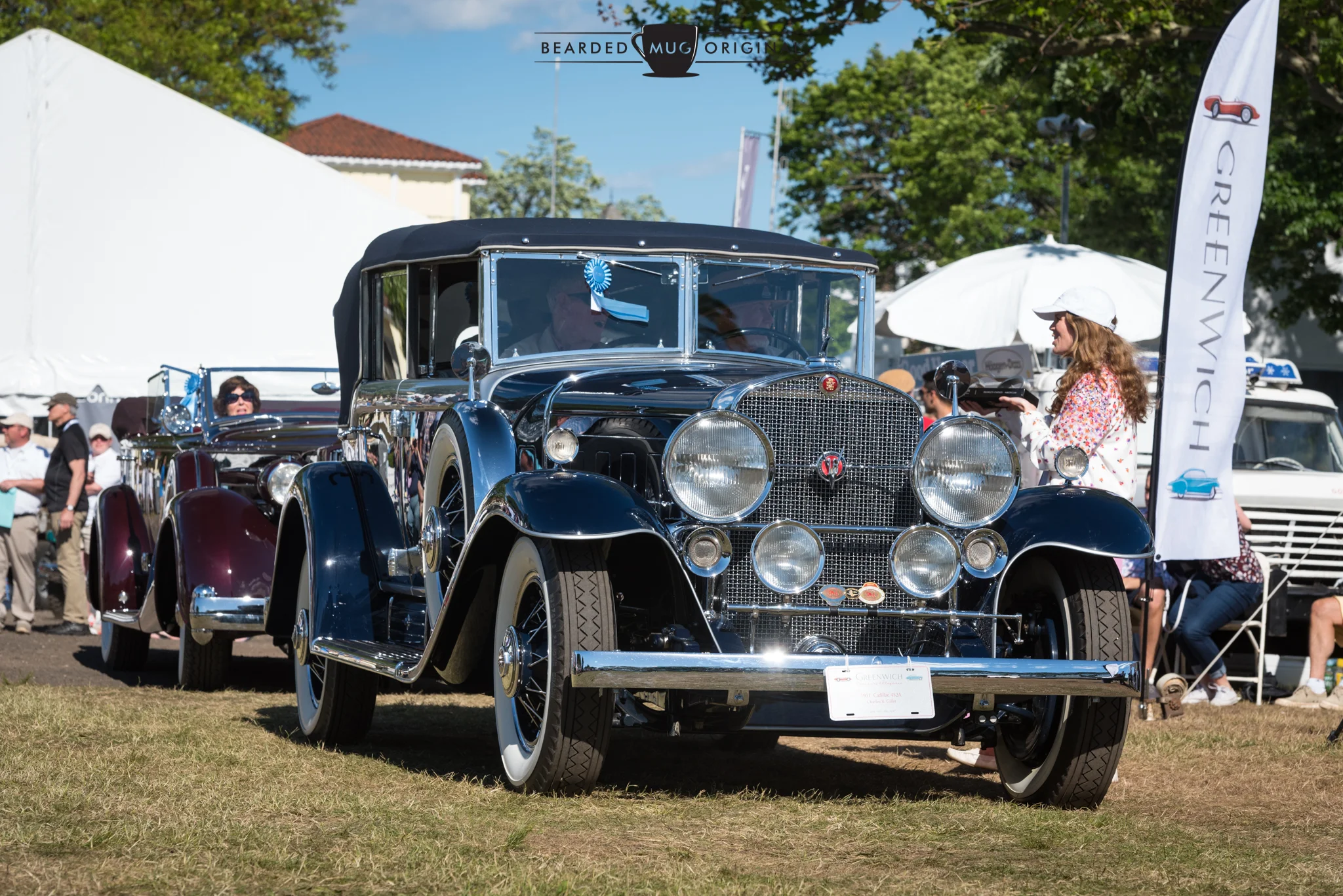 The People's Choice Cadillac approaches the podium. The Best in Show Packard can be seen behind it.