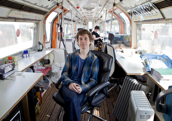 Auro Foxcroft, owner of Village Underground, sitting in one of the venue's train carriage start-up spaces.