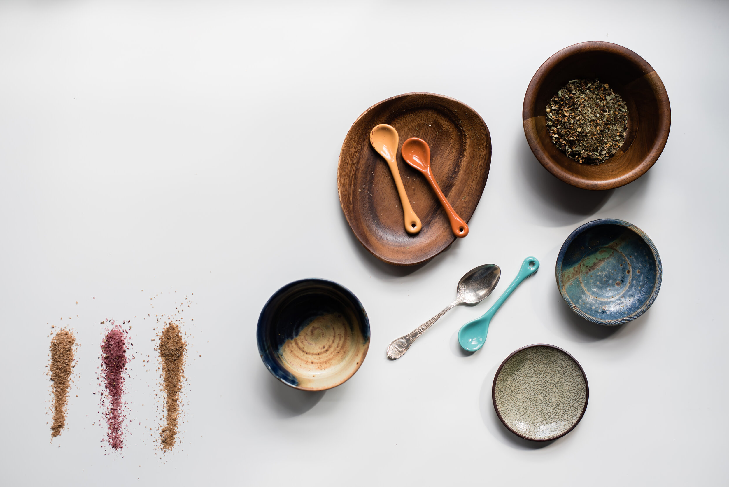Studio photo of wooden bowls, spoons, and dried spices 