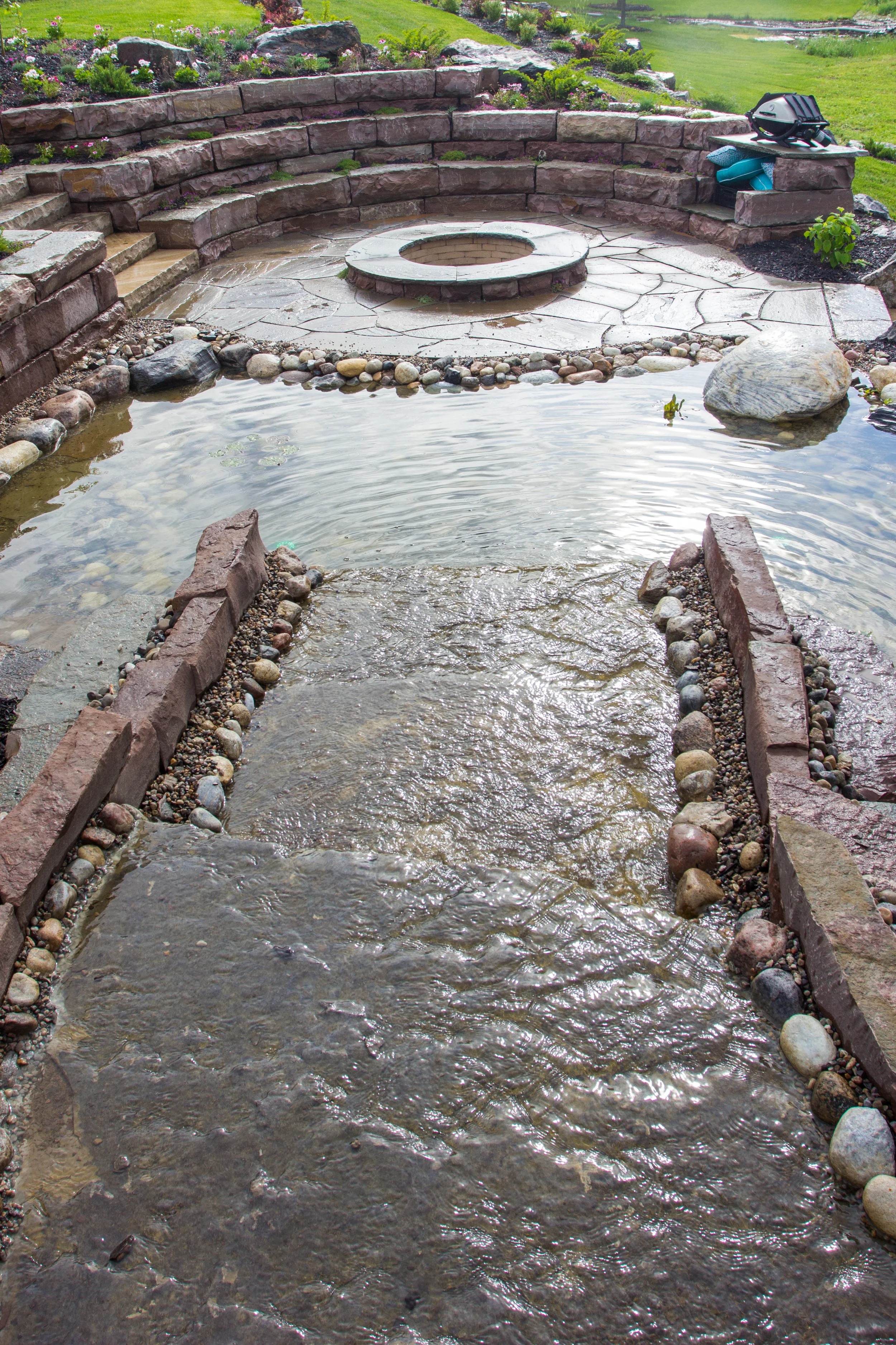 Waterfall dropping into the fire pit pond using large slabs of Madoc stone.