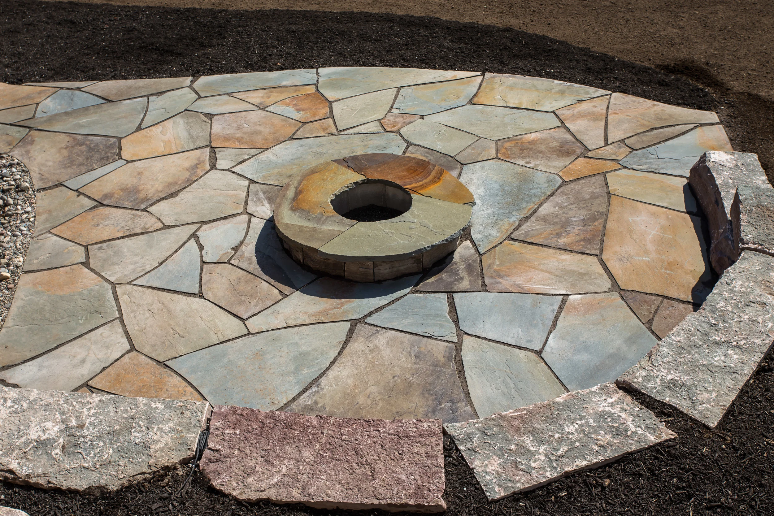 Fire pit patio with Owen sound fire pit walls capped with Pennsylvania flagstone. Patio is also Pennsylvania flag and sitting wall is Madoc stone.