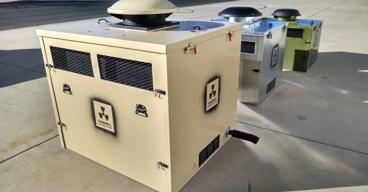 Three portable generator enclosures lined up on pavement in bright sunlight, with vented sides and roof fans.