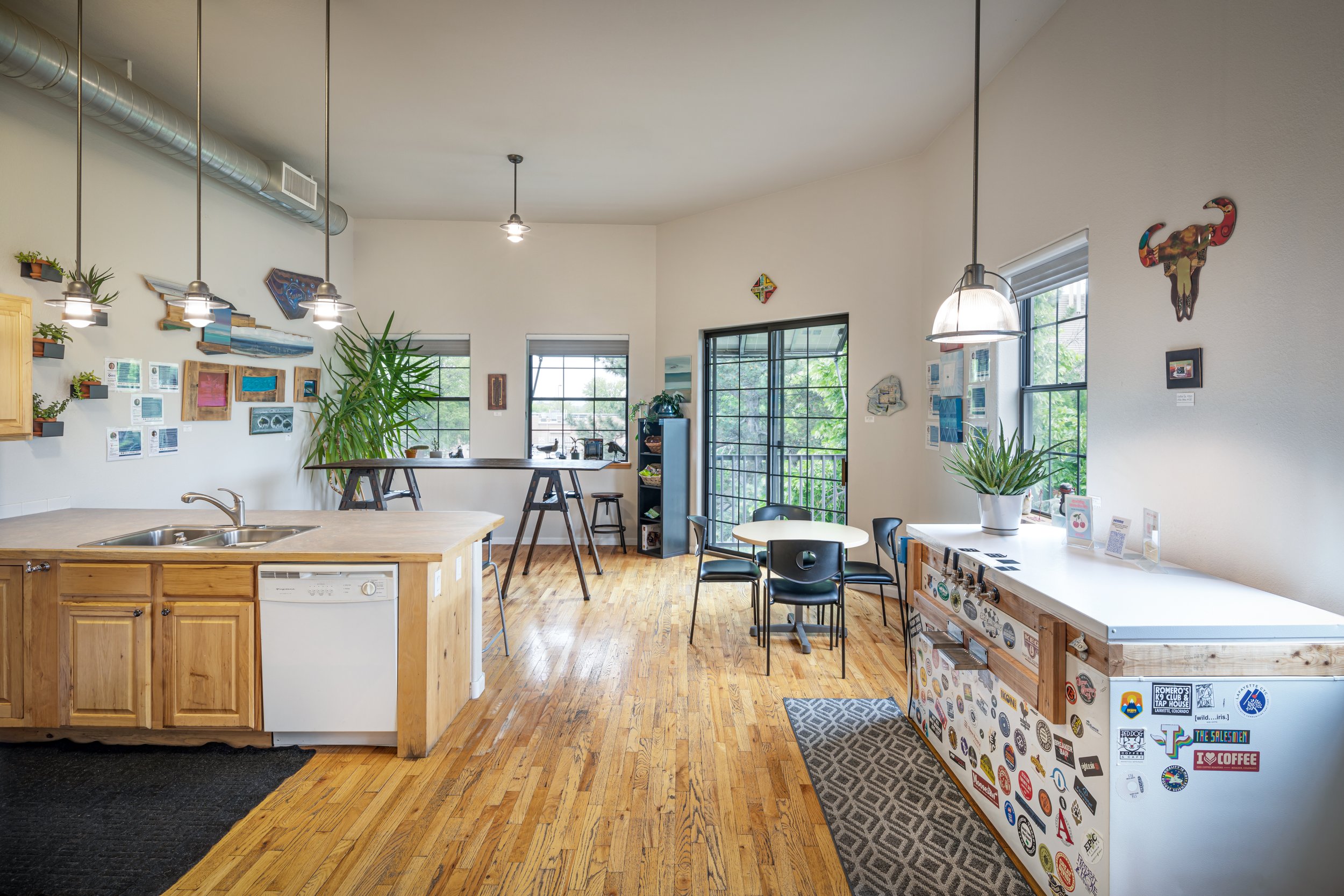Kitchen and dining area with plants and wall art.