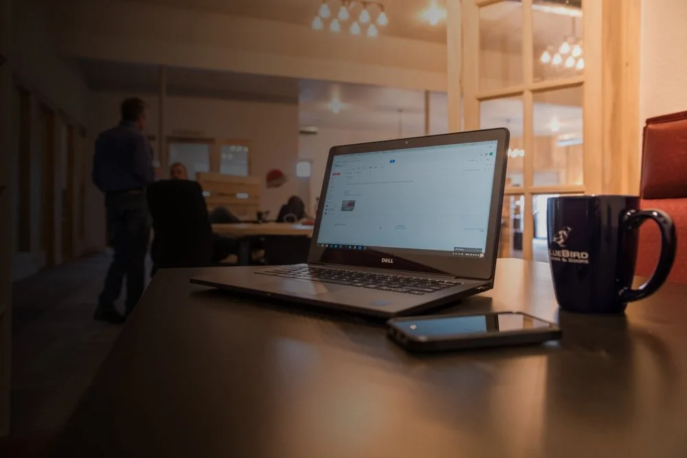 Dedicated desk setup with wooden partitions and office chairs in coworking space.