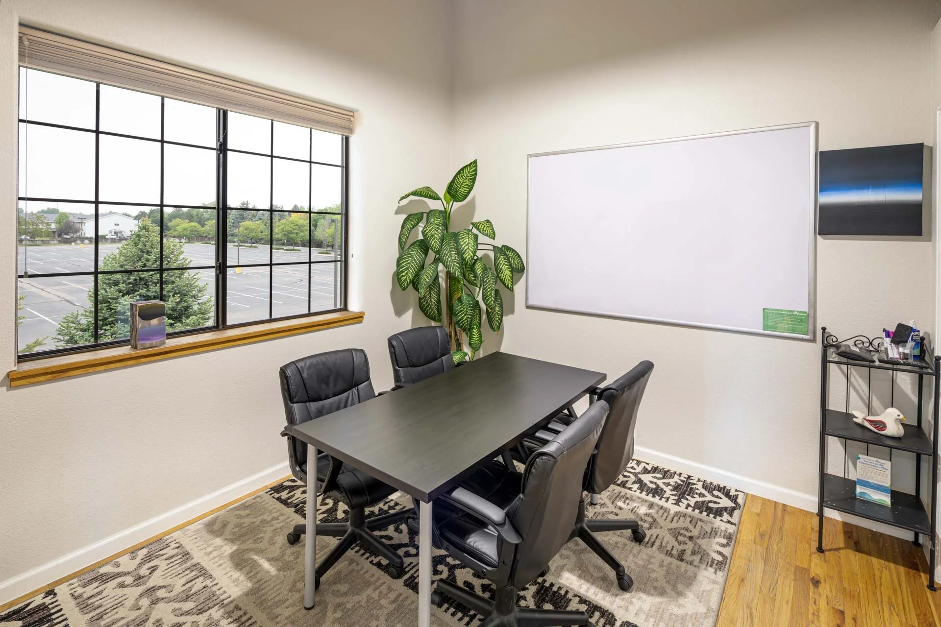 Small meeting room with table, chairs, and whiteboard.