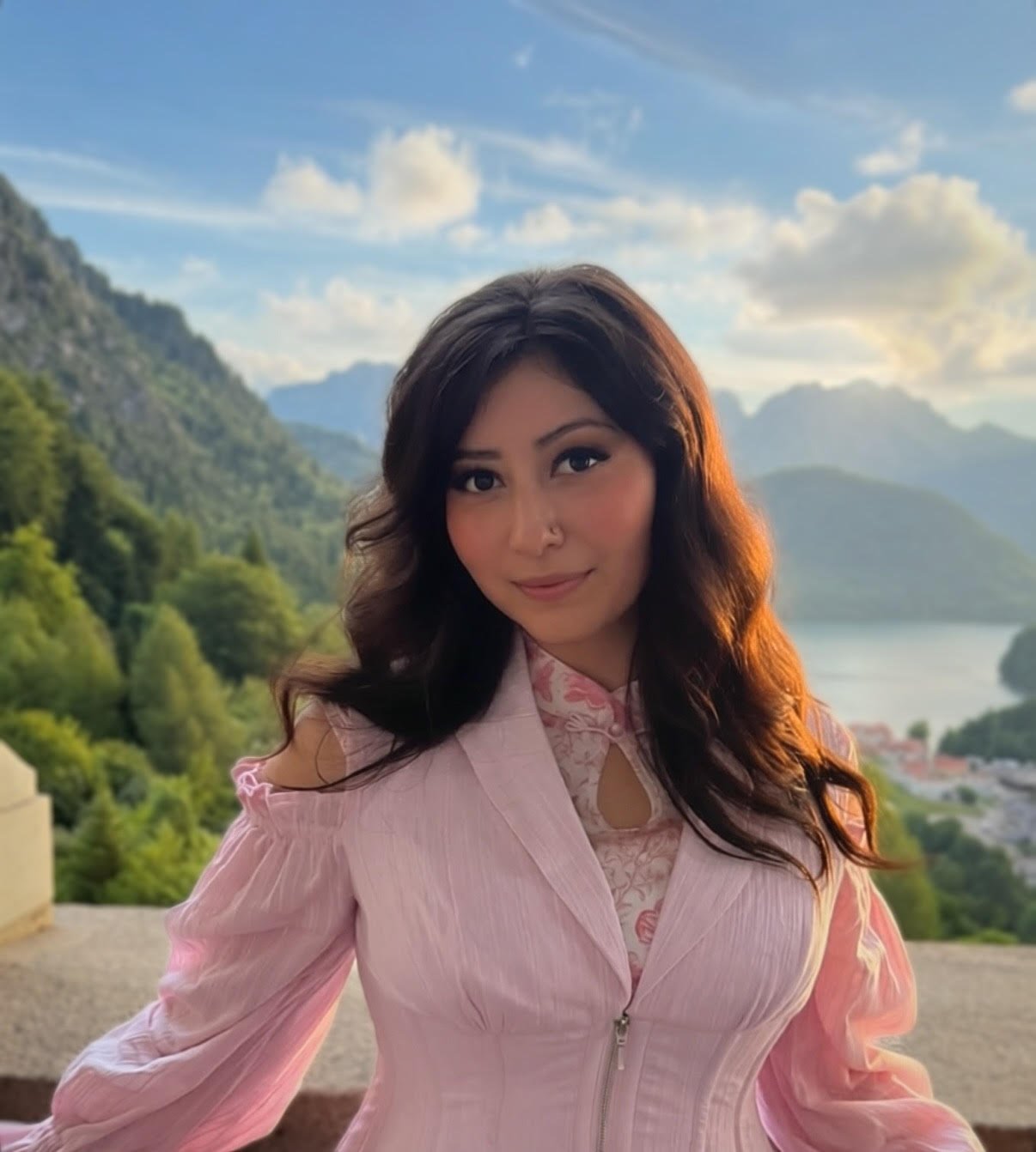 Taylor wears pink outfit in front of outdoor landscape.