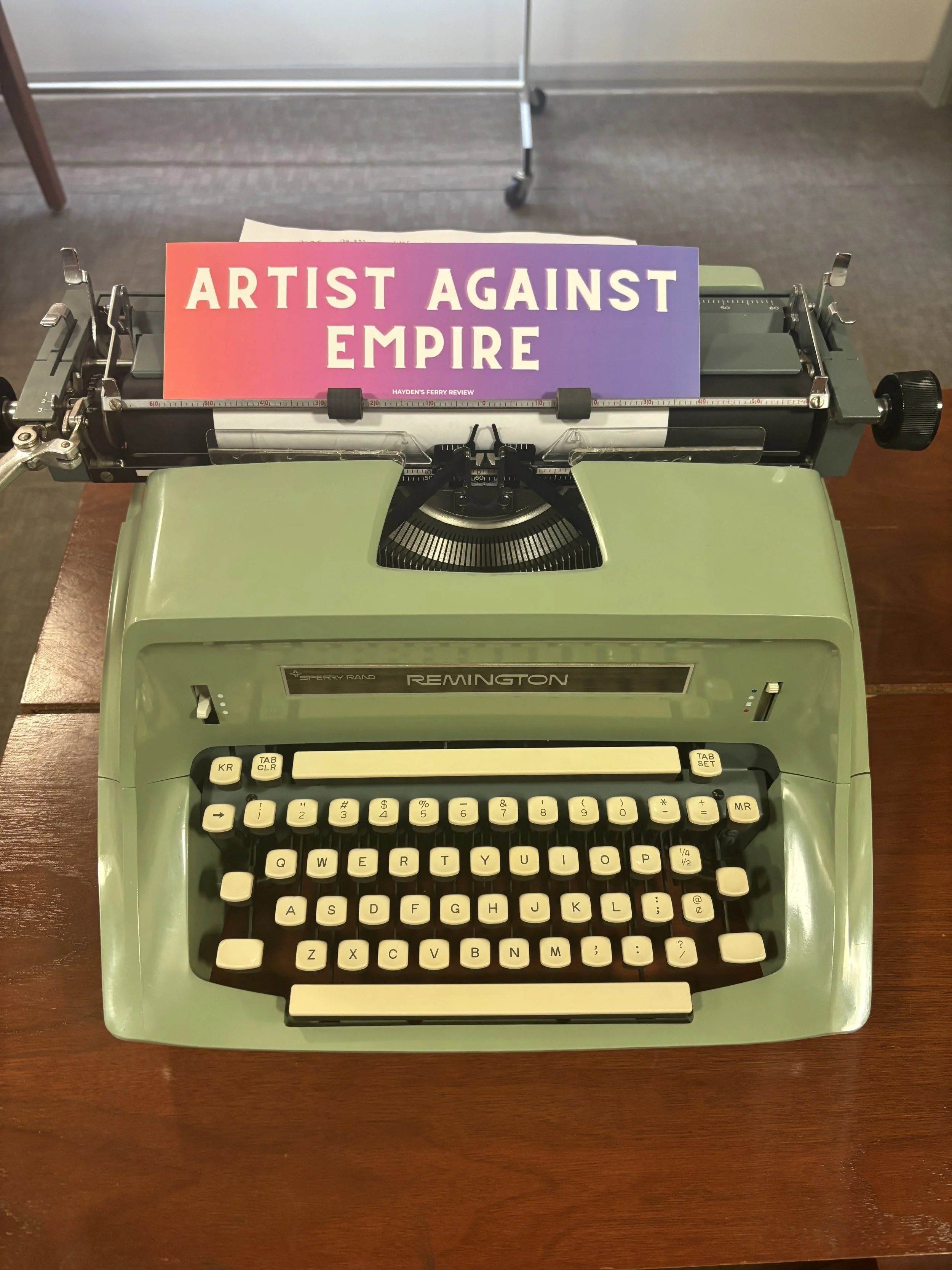 Artist against empire bumper sticker rests on a mint colored type writer