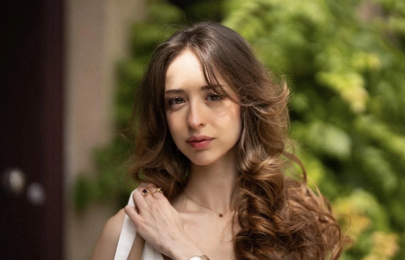 Headshot of Celeste in front of green foliage