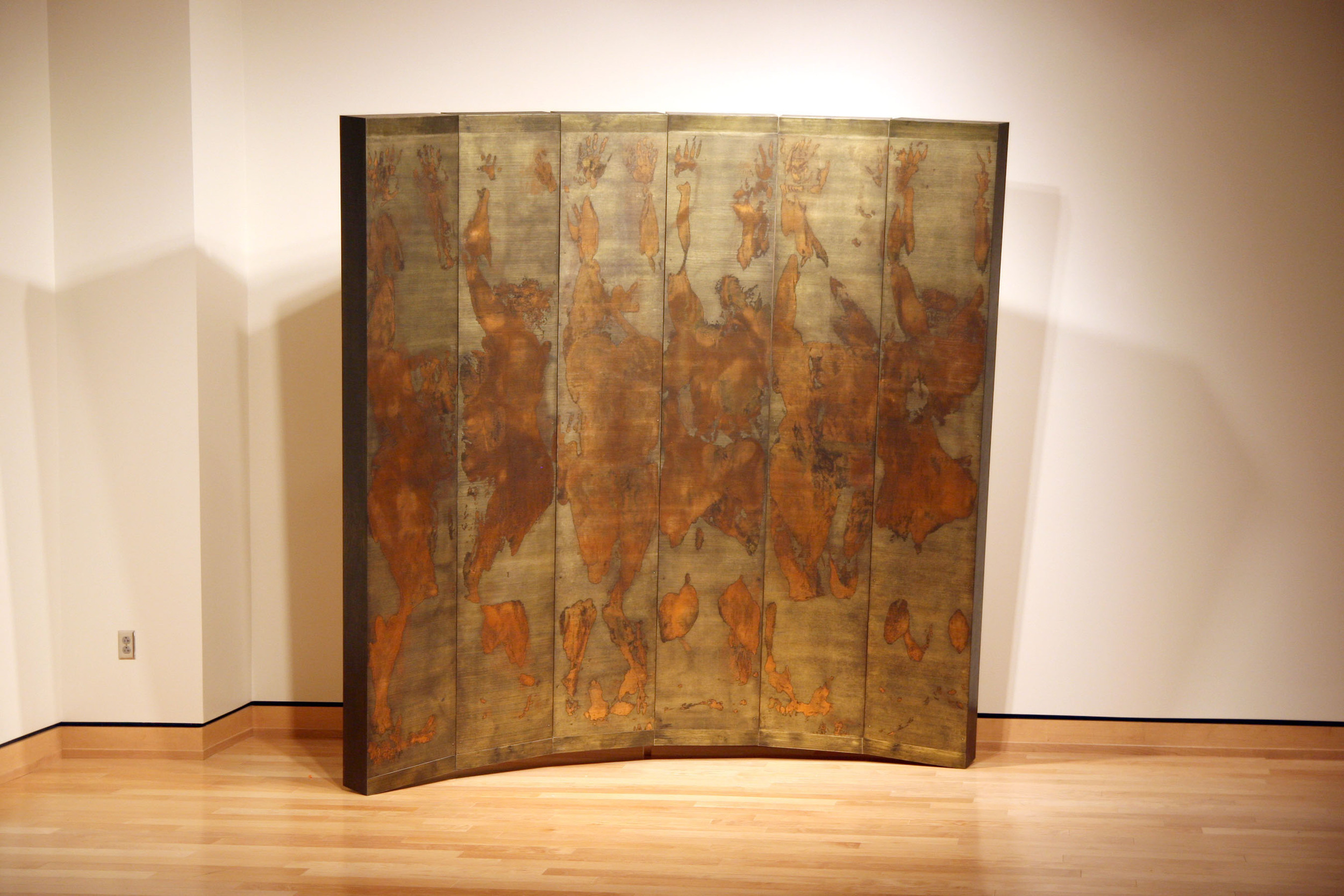 Pusher woodcut monoprints, mounted on prepared boxes, assembled in a tilted horizontal arc form paper, ink, metallic foil, wood, oil paints, hardware 96” x 96” x 24” 2010