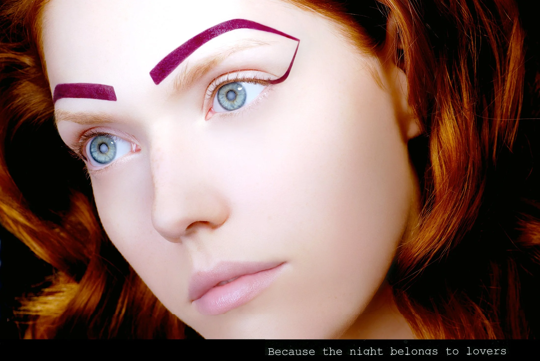 Close-up of a woman with bright red hair, blue eyes, and creative purple eyeliner makeup. She has fair skin and partially visible lips, looking contemplative. The image includes a black border at the bottom with white text that reads, "Because the ni