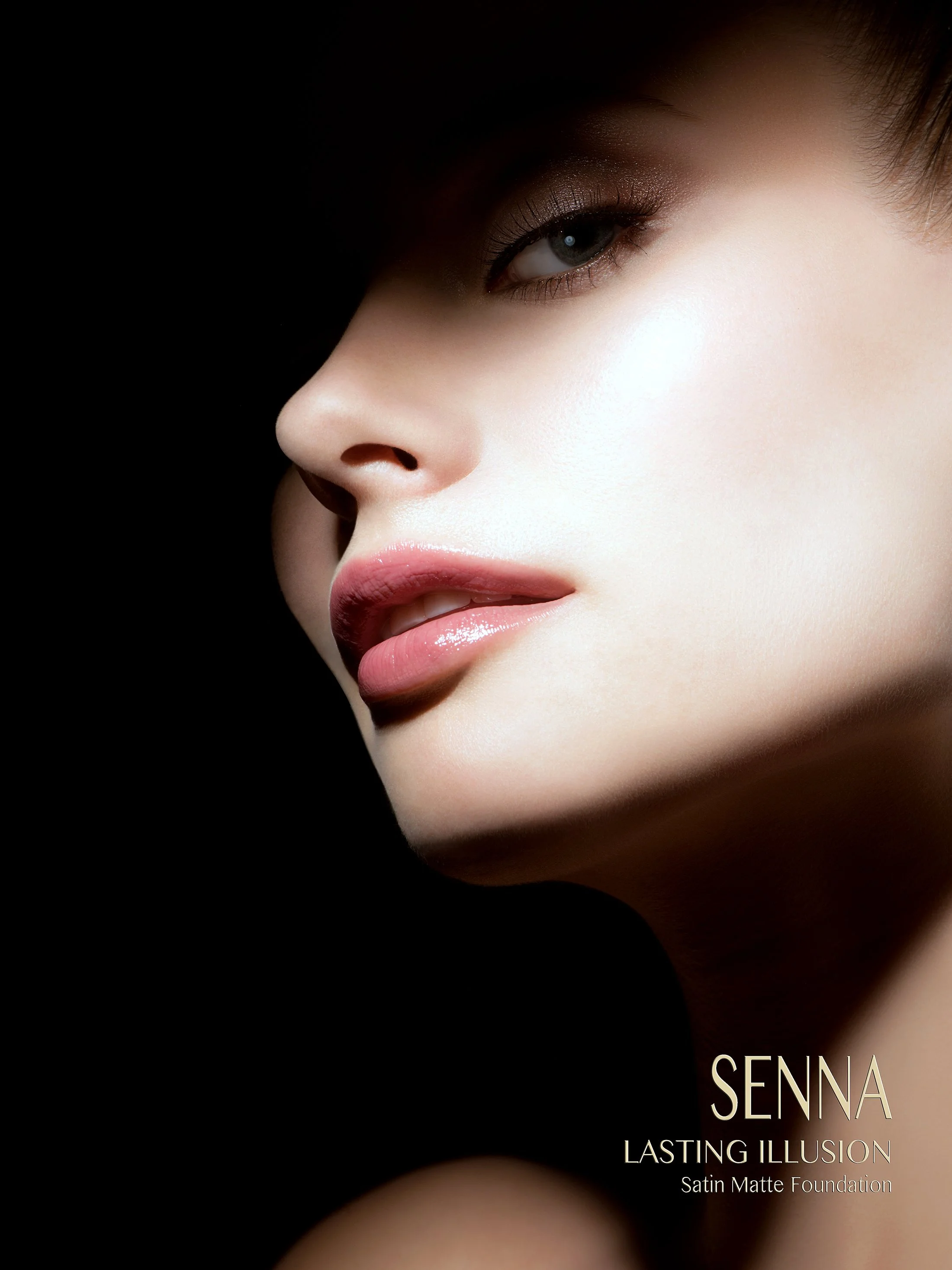 Cinematic commercial beauty shot for Senna Cosmetics by expert photographer Daniella Hehmann. Side profile featuring high-gloss lips and a velvet skin finish, sculpted by dramatic, painting-like side lighting. Makeup by Eugenia Weston. Munich and L.A