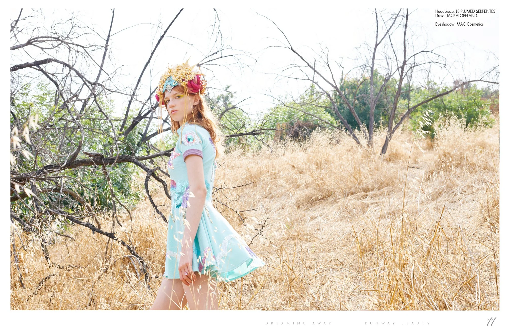 Fashion editorial shot by Daniella Hehmann, of a model wearing a pastel blue dress with floral embellishments, a floral headpiece, and has long wavy hair. The image has bright lighting and an dreamy atmosphere.