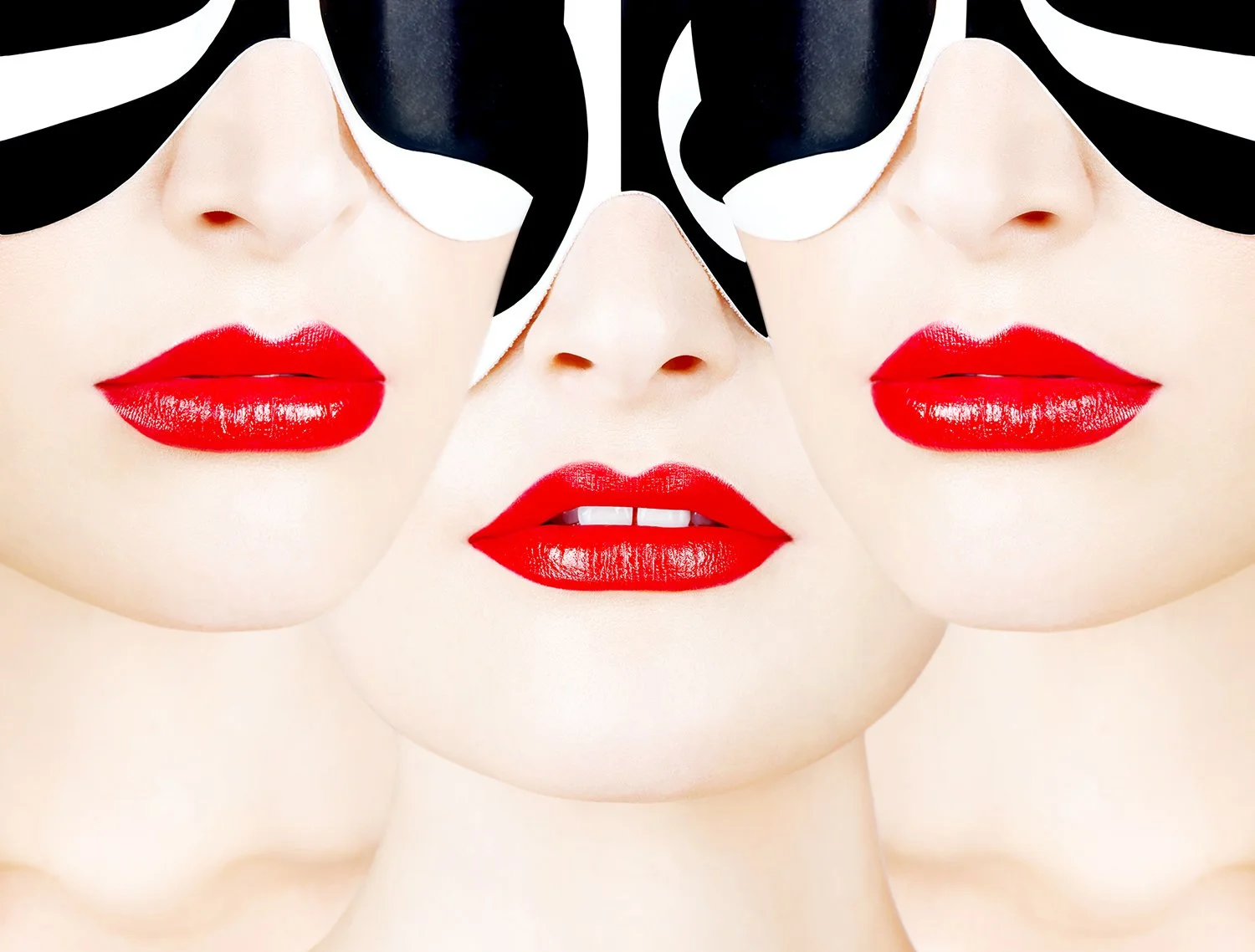 Graphic beauty editorial by Daniella Hehmann featuring a trio of models with bold red matte lips and high-contrast lighting to accentuate flawless dewy skin. Expert L.A. & Munich based beauty photographer.