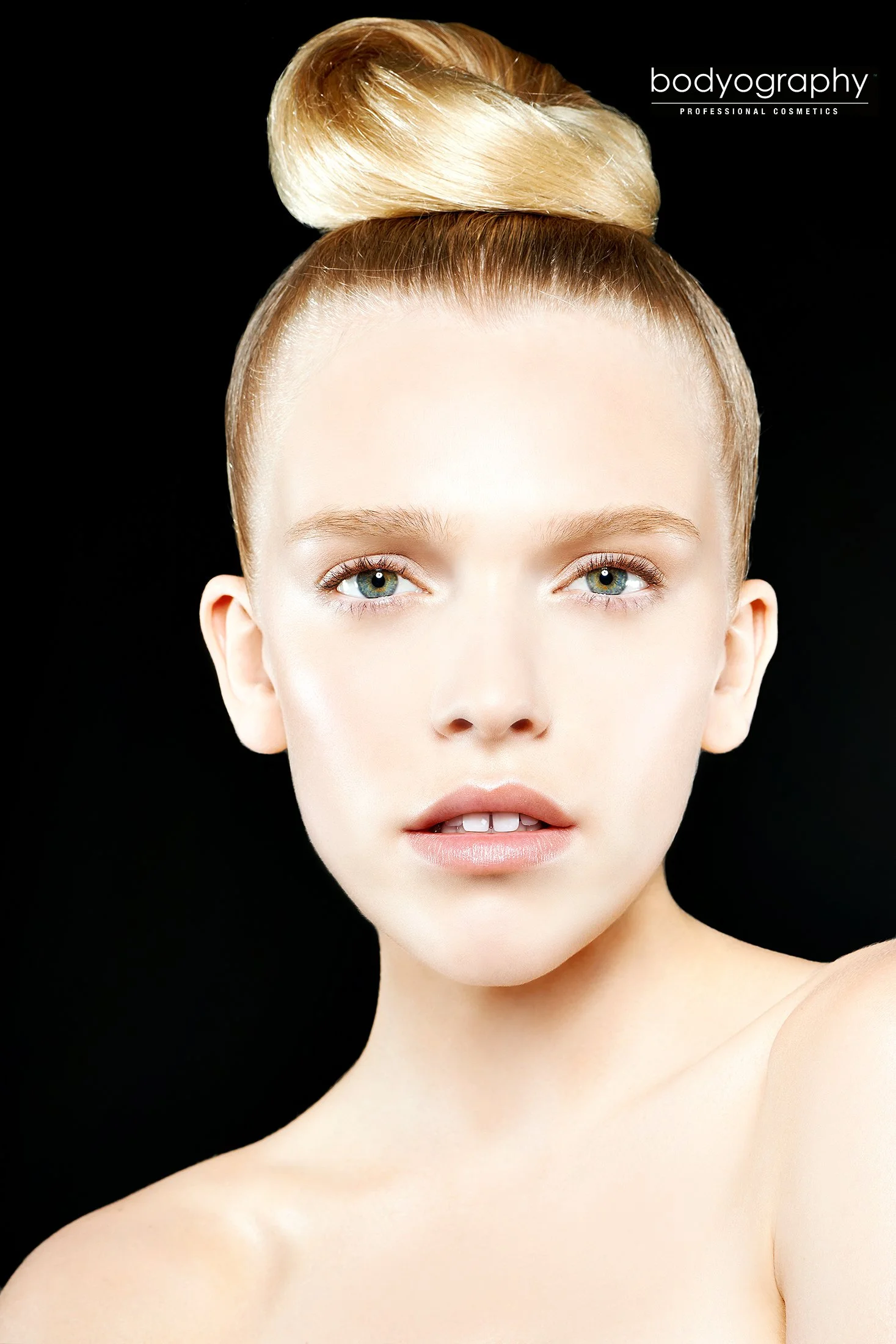 Dramatic commercial beauty photography for Bodyography Cosmetics by Los Angeles beauty photographer Daniella Hehmann. High-contrast studio lighting against a deep black background highlights bold lip pigments and flawless, radiant skin. Expert advert