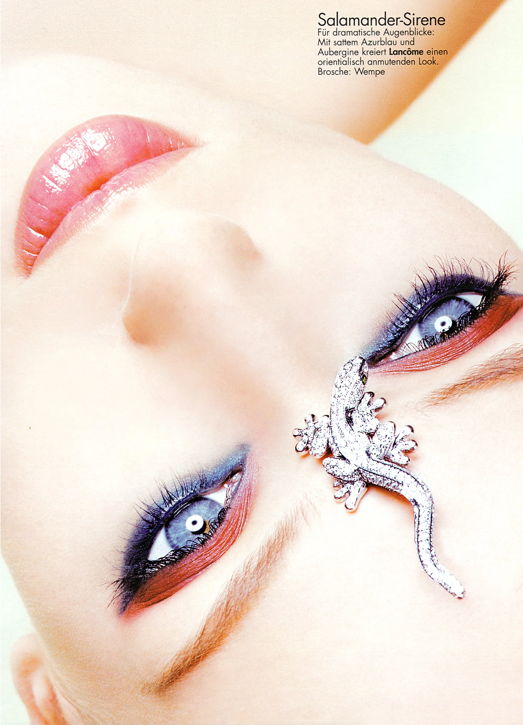 High-gloss beauty editorial for German Cosmopolitan by expert photographer Daniella Hehmann, featuring a model with high-shine pink lips and a sculptural lizard accessory. Skin is luminous and dewy, shot in L.A. under vibrant, high-definition studio 