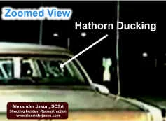 Hathorn reacts to the threat, ducks down behind his vehicle.