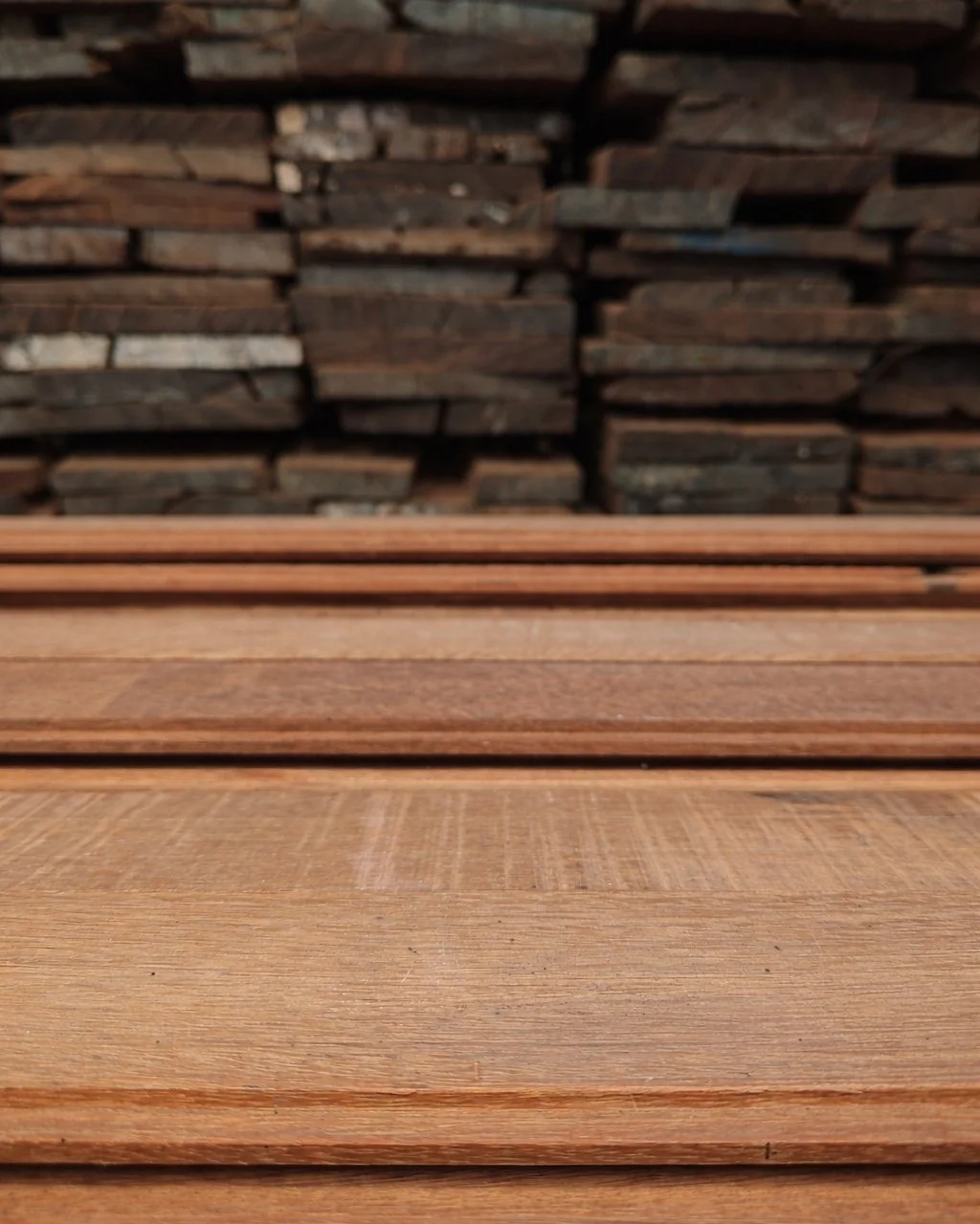 From forgotten structures to foundations for the future.

In the background: salvaged ironwood planks once part of bridges, homes, or docks.
In the foreground: reclaimed ironwood flooring ready to begin a new chapter.

At Kaltimber, we don&rsquo;t ha