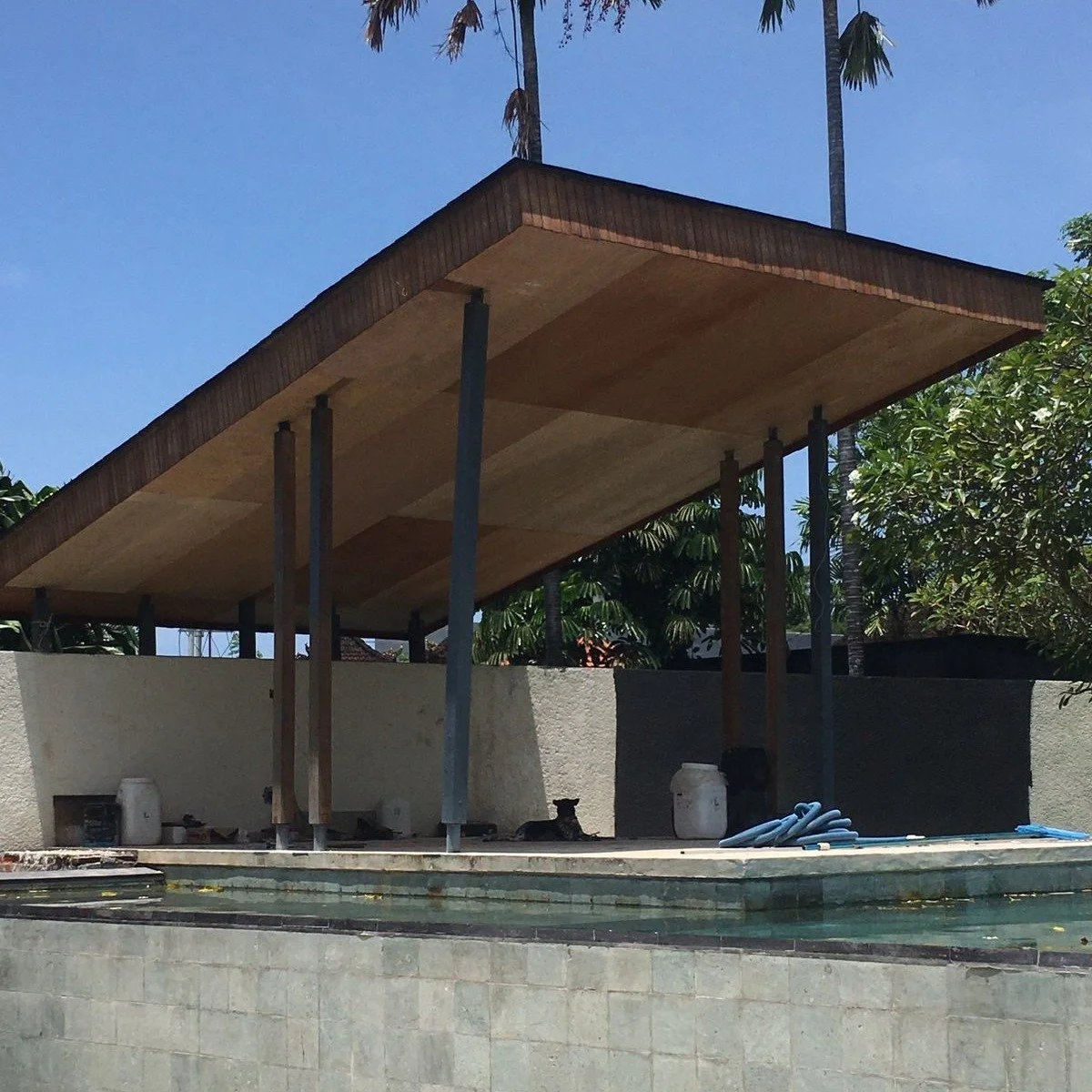 Understated architecture is often about one material doing the heavy lifting.

At Villa Aga in Canggu, reclaimed ironwood defines the entire canopy. The warm timber ceiling gives weight and presence to an otherwise minimal structure of slender column