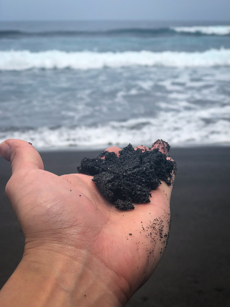 Dark black sand at Waipio Beach