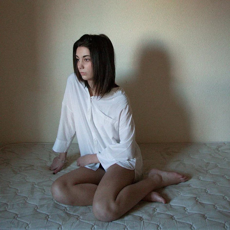 Soledad mujer adolescente sentada en la cama.jpg