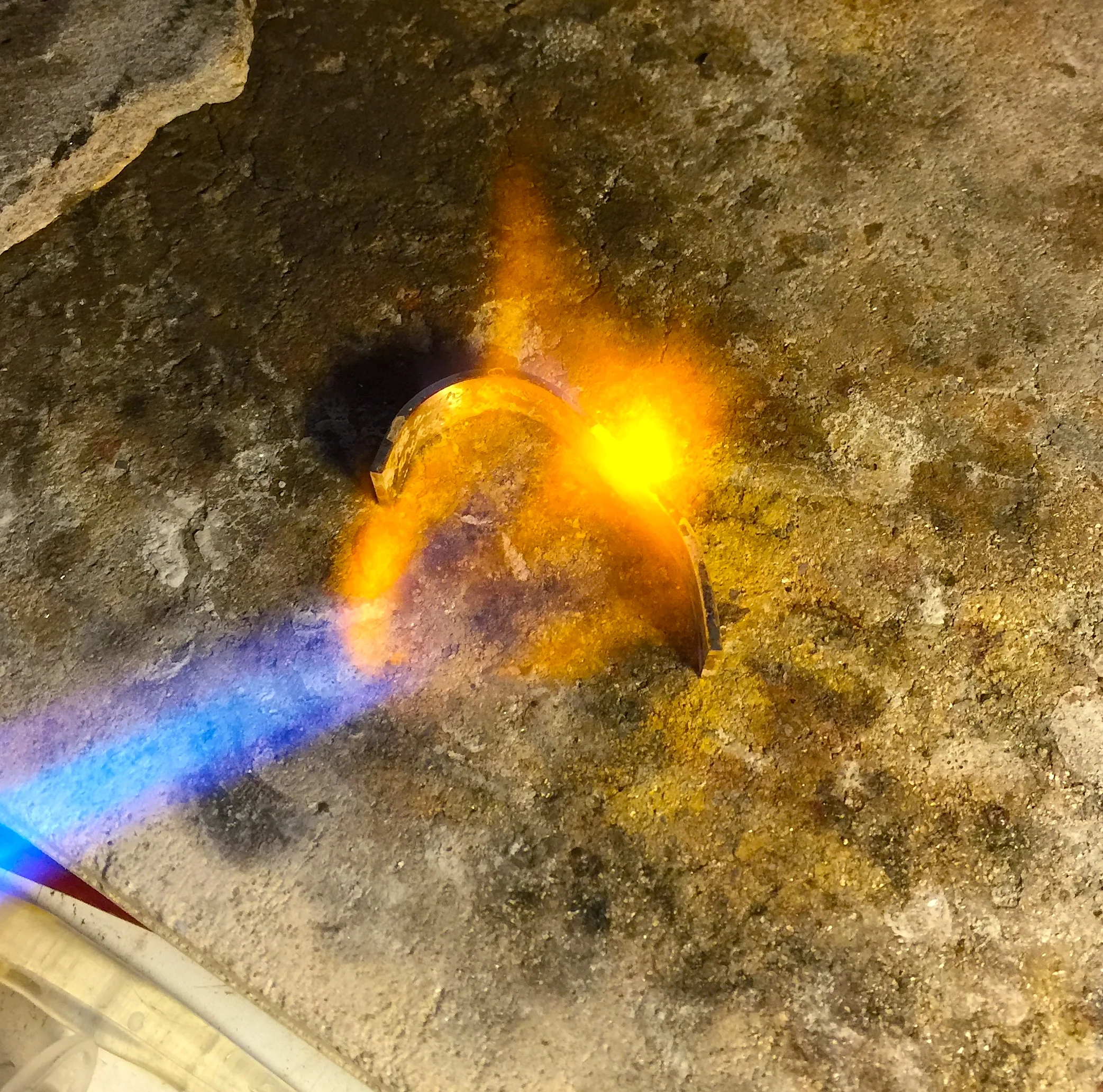 Annealing the heavy gold with a blowtorch to soften it, and allow it to be curved. 
