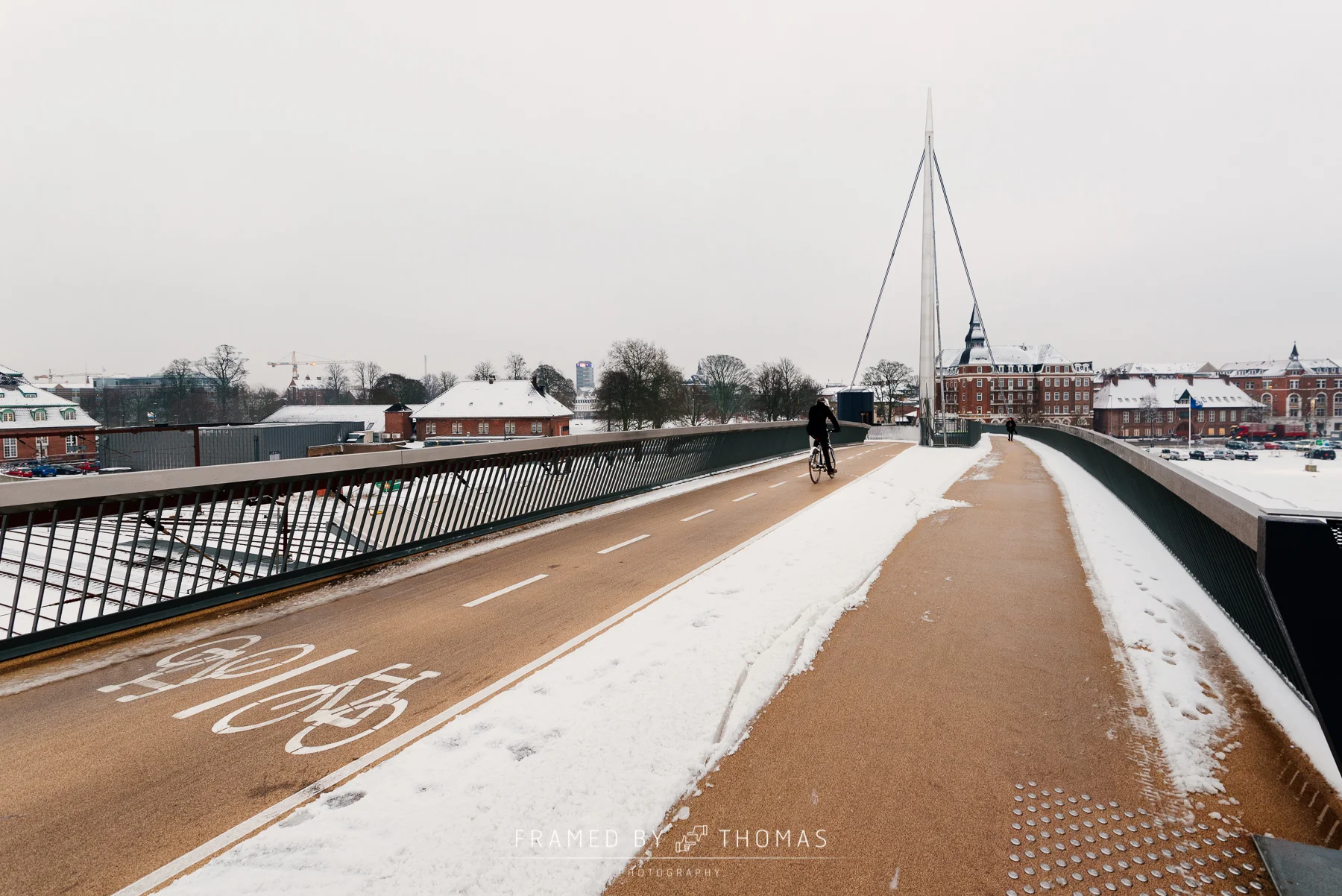 Cyclist in the snow on Byens bro (bridge) in Odense, Denmark