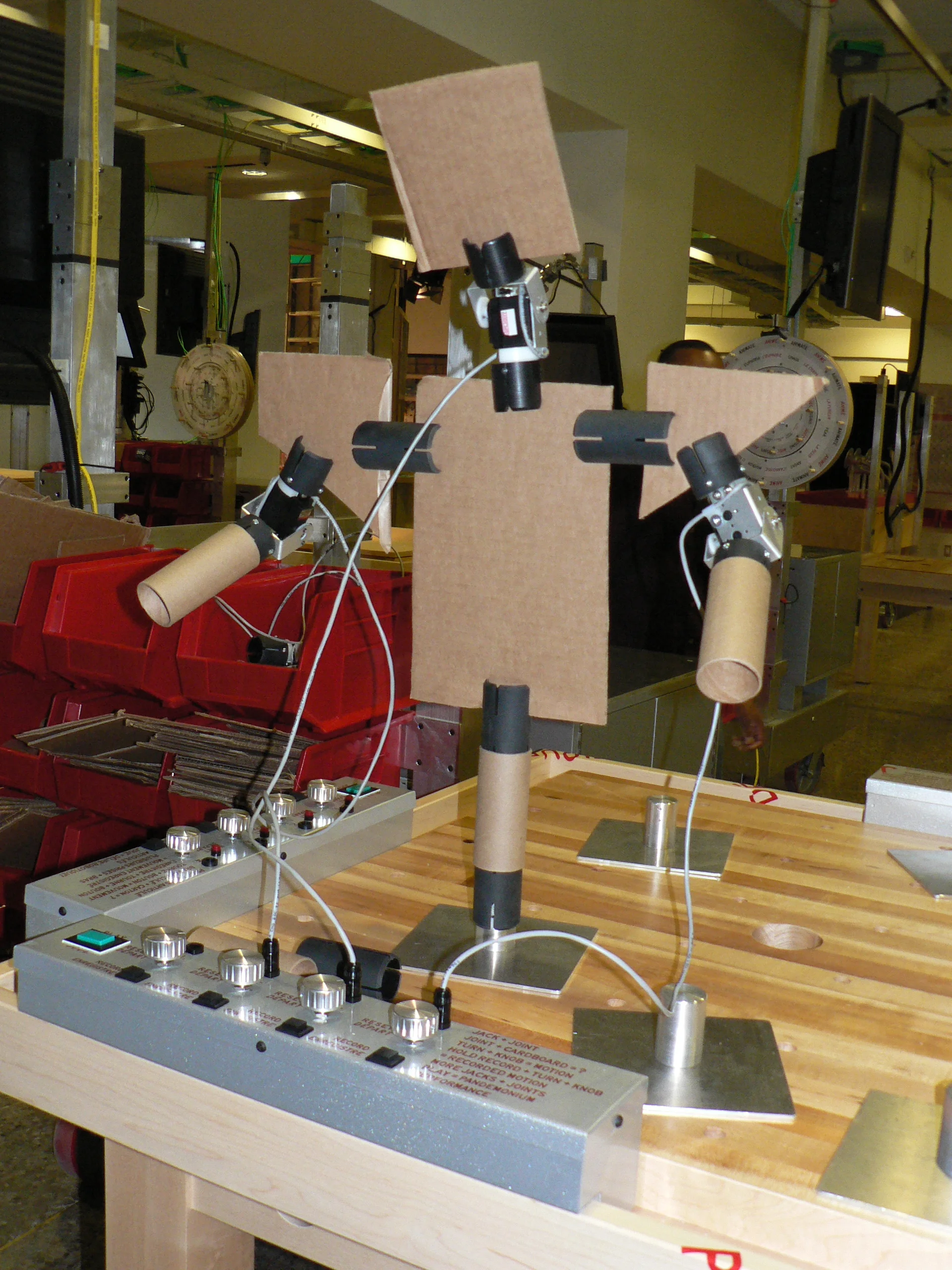  Exhibit floor work table with articulated figure made out of card board sheets and tube. 