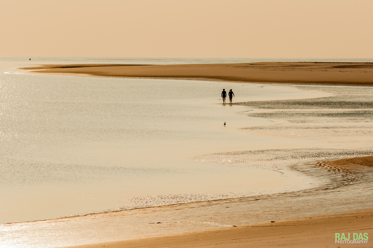A pair of early morning walkers on the beach