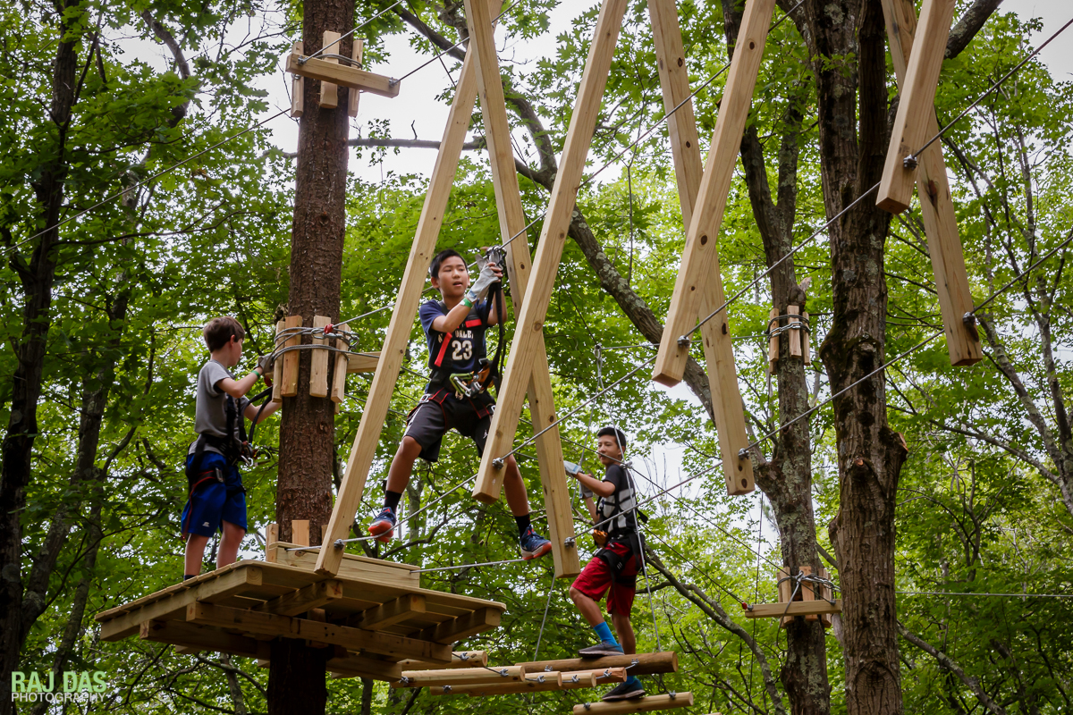Original full image of kids on a challenge bridge that's on the right of the billboard