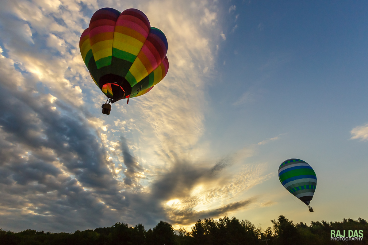 Balloons sail away as a dramatic sunrise fills the skies