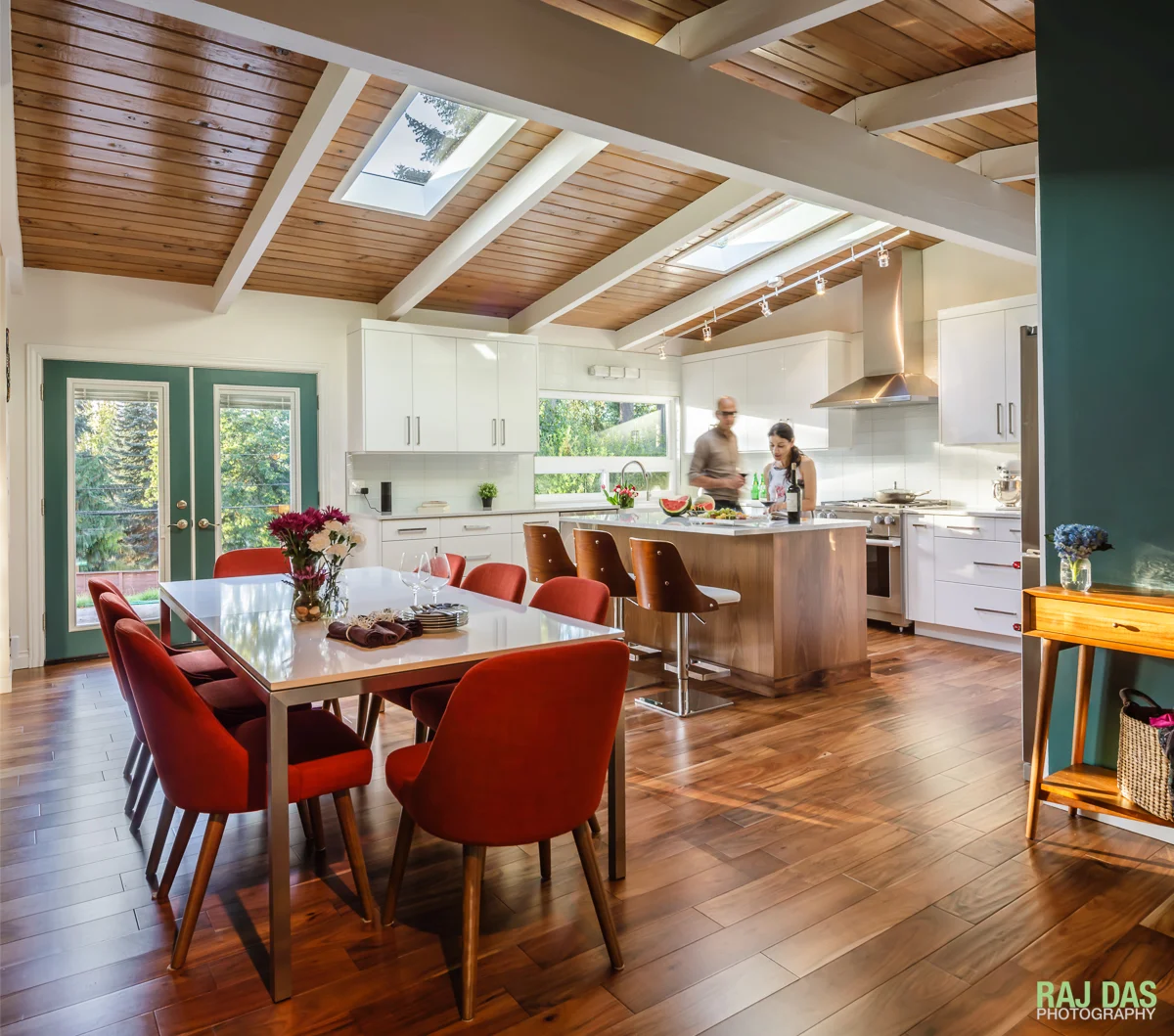 A view of the dining area and kitchen as the warm late afternoon sunlight streams in.