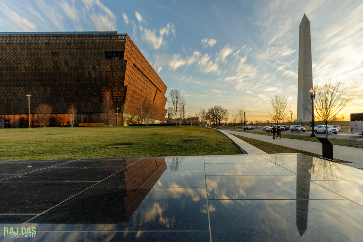 The Museum and the Washington Monument reflected on the black granite retaining wall