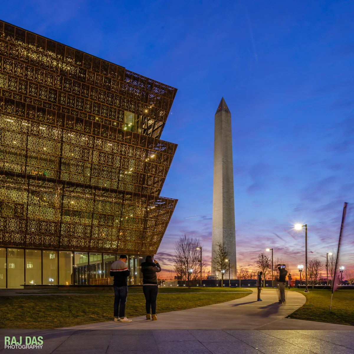 Visitors taking in the view of the Washington Monument from the Museum at dusk