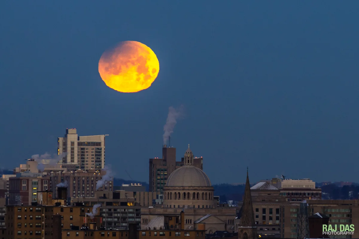 A close shot of the super blue blood moon with the dome of the First Church of Christ, Scientist in Boston visible in the center of the frame.