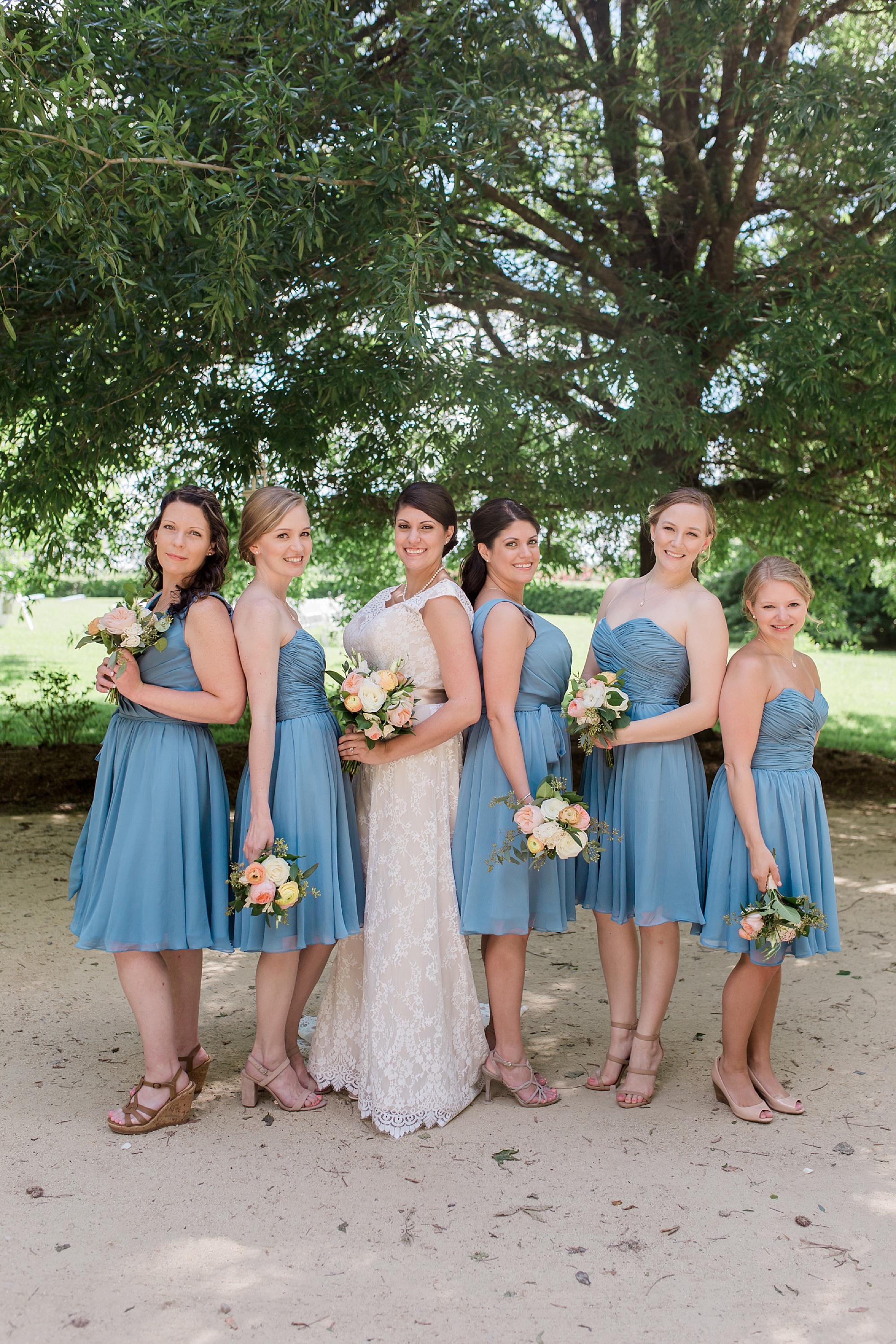 Classy blue bridesmaids with white and peach flowers