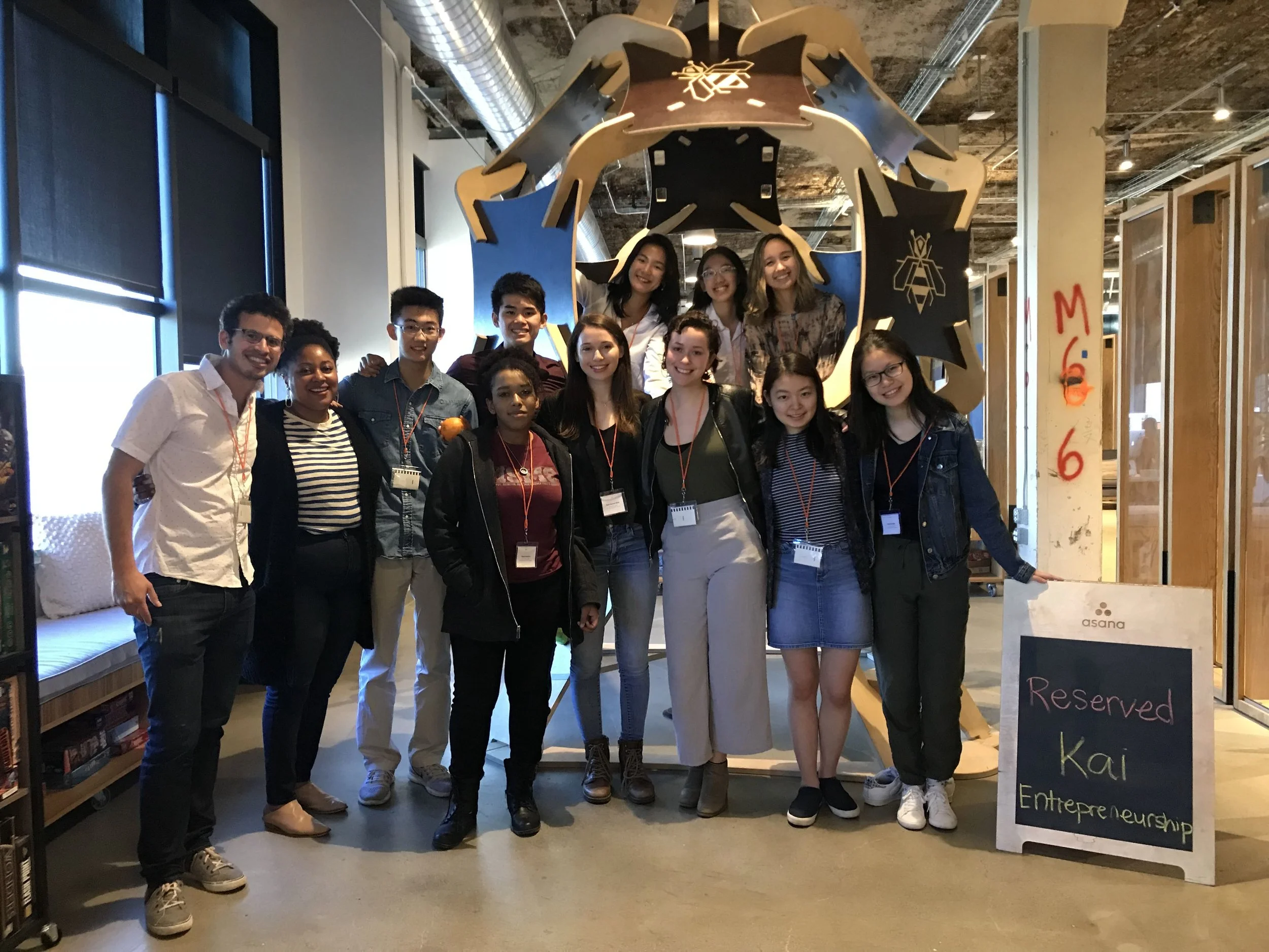 Kai Wesleyan team and Smiley Poswolsky posing in front of an display that Asana employees brought to Burning Man