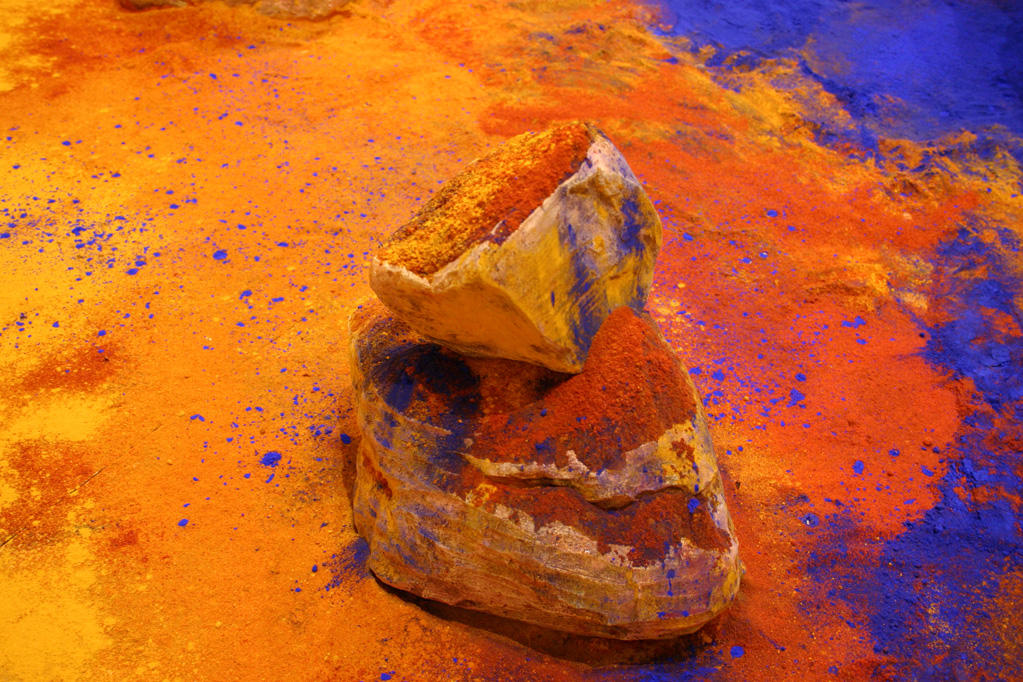 Detail of the red chili powder, turmeric and blue pigment ( nee) on the ceramic boulder