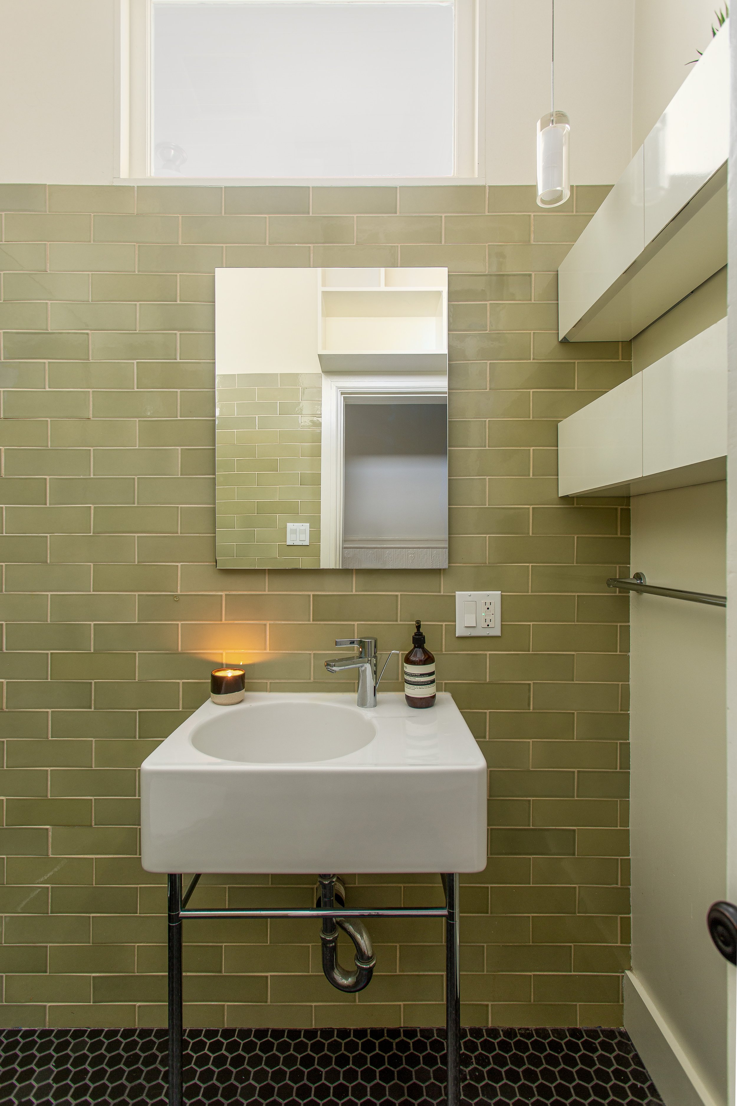 Bathroom with Olive Colored Tiles and a Candle