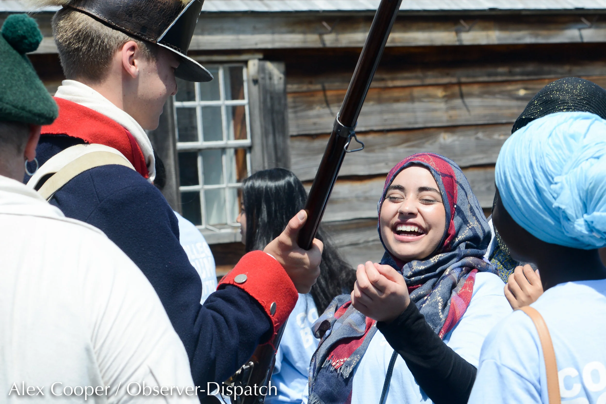 Utica resident Malak Alazaizi, a student with Utica’s Upward Bound outreach program, smiles and laughs as Hayden Johnson, left, shows the functions of a musket on Friday, July 20, 2018, at the Fort Stanwix National Monument in Rome. [ALEX COOPER / O…