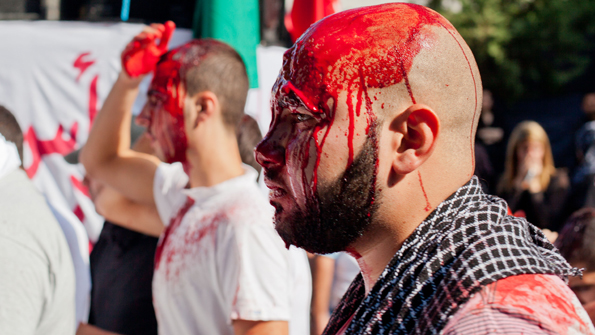 A blood-soaked man marches in this Ashura procession. (Courtesy James Haines-Young)