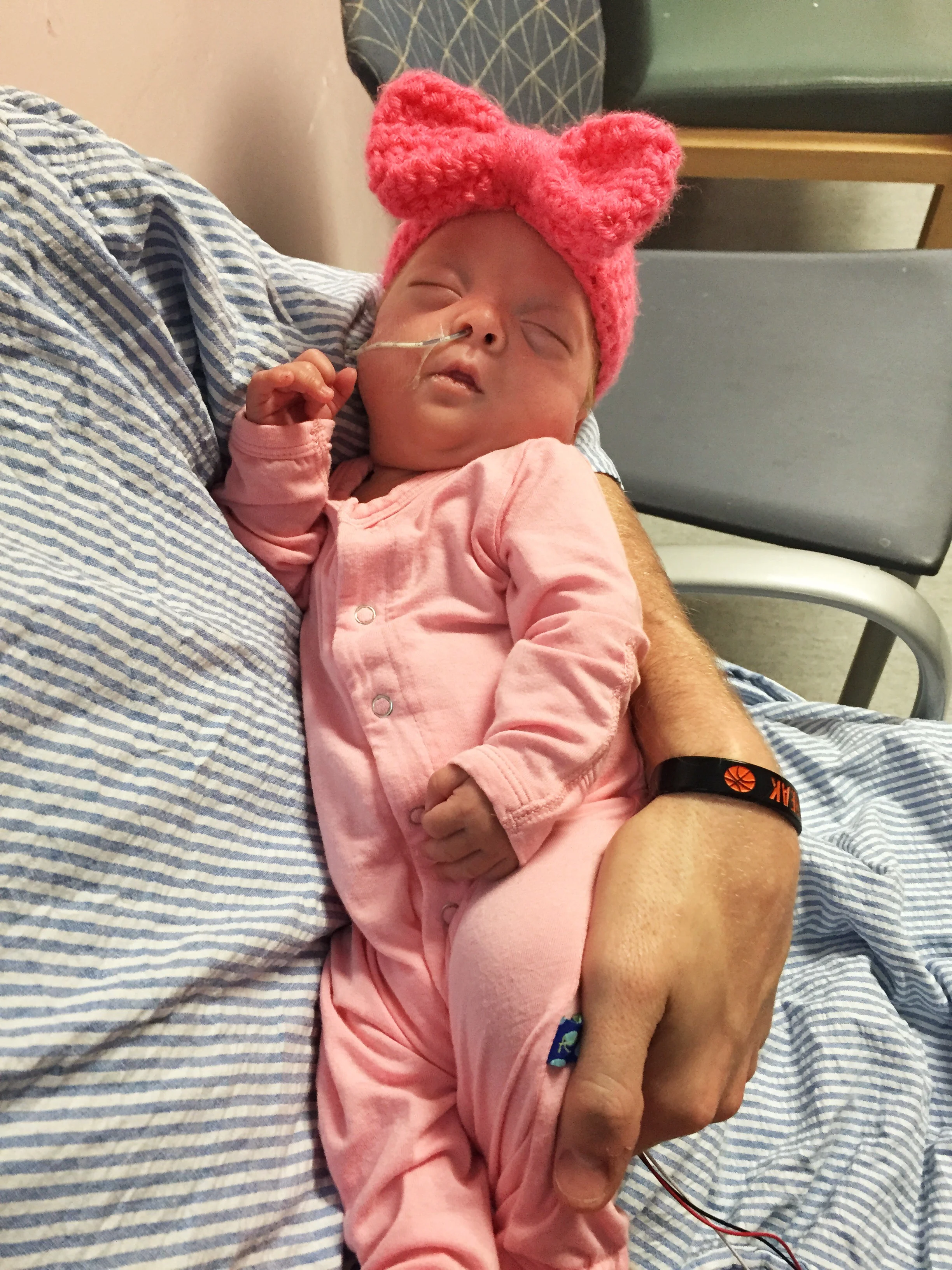 Happily sleeping after a busy day of breathing on her own and taking four bottles! She's officially grown out of her first hat!