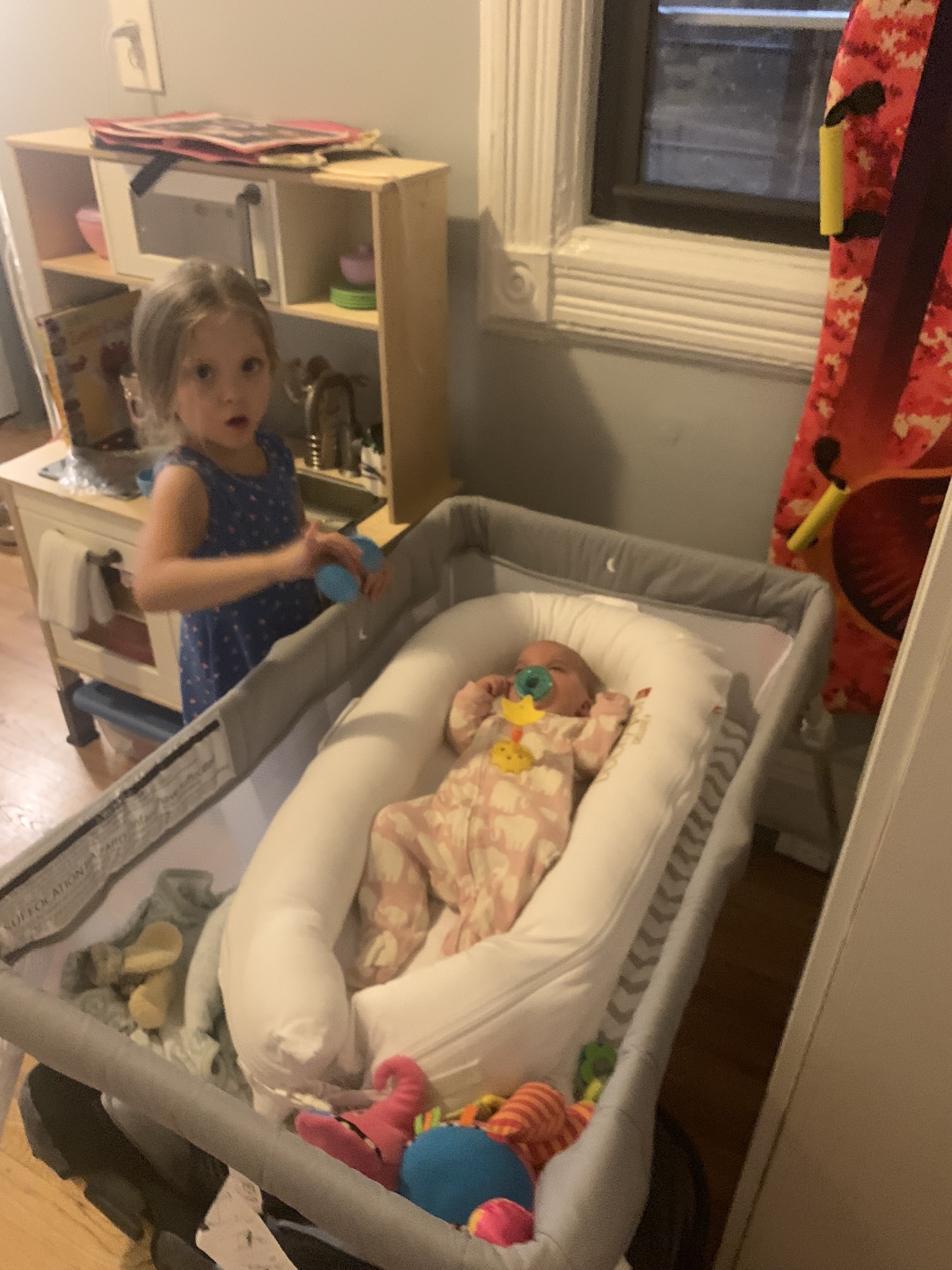 Rob and I were in our room trying to install a new window A/C and Felicity was crying in another room in her bassinet. We couldn’t get to her, but then realized the crying had stopped. When Rob went to check on her, he found big sister Lucie soothing and calming Feli down. Lucie gave Felicity the pacifier, put the yellow toy on her chest, and sang a song while shaking the rattle. <3
