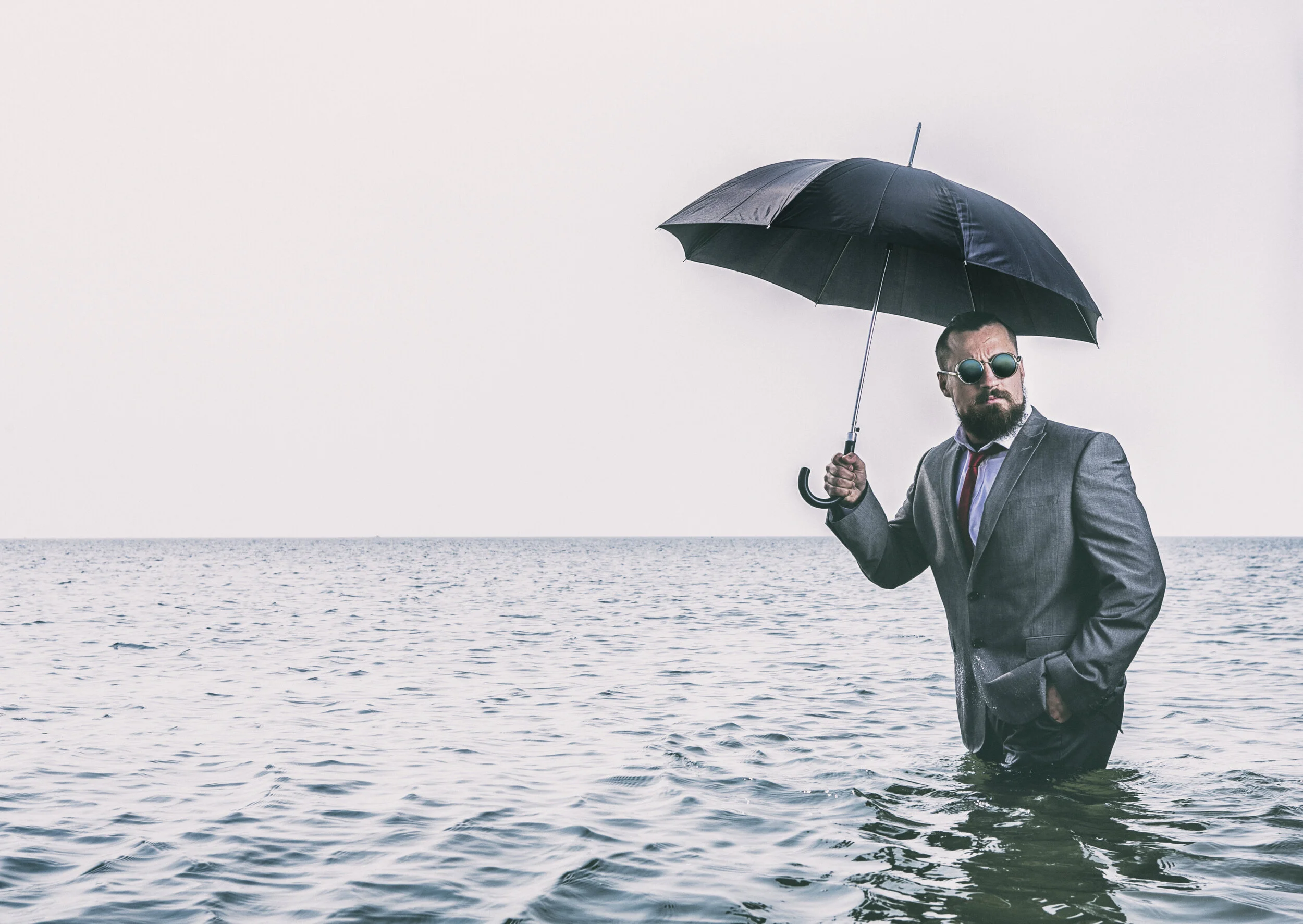 man_in_black_jacket_holding_umbrella_while_standing_on_water-scopio-6c19d66e-8e61-4218-b993-2a537b741c3a.jpg