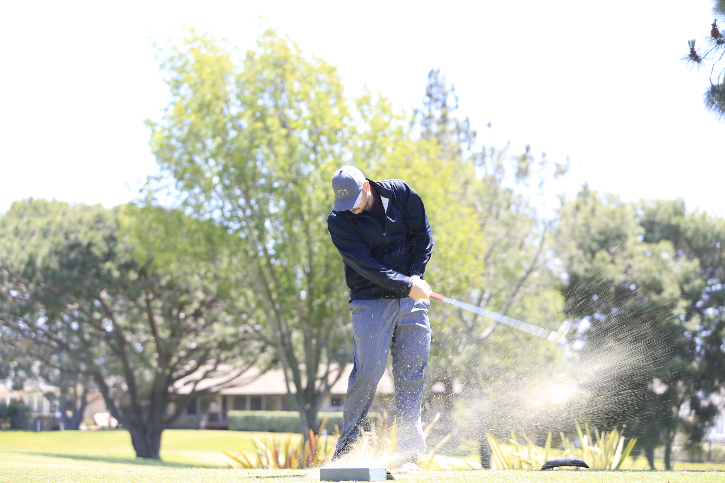 Golfer smacking a ball down range.