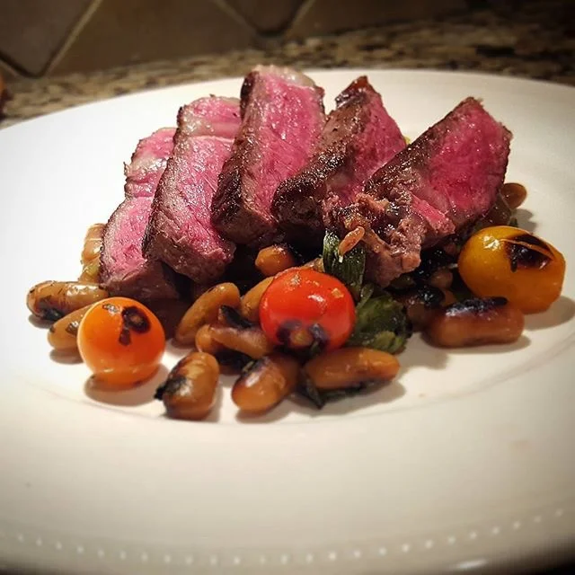 @the_Chrishill searing a NY Strip on his Griddle, with bean ragout and blistered tomatoes..whoa!