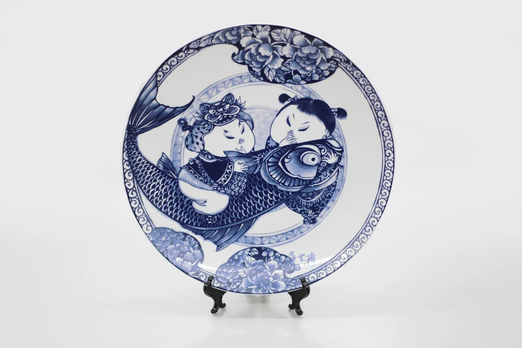 胖娃娃與招財魚,都是體形豐滿者,魚的諧音即為「餘」,有富貴有餘的意義外,兩人為家庭共同打拚的夫妻之情,有餘且知足,更是感情恆長的象徵。 楊莉莉青花:富貴有魚十二吋瓷盤畫 尺寸(直徑 x 直徑 x 高)30.5 x 30.5 x 4.0 cm 材質:陶瓷 產地:台灣 包裝:高級燙金紅黑盒裝 建議售價:2390 元 庫存狀態:等待進貨