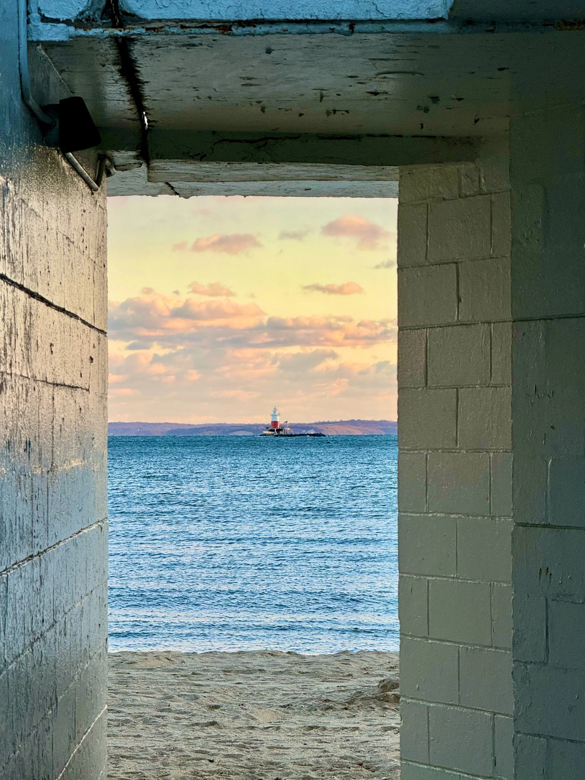 Concrete doorway framing the sea and a pastel sky