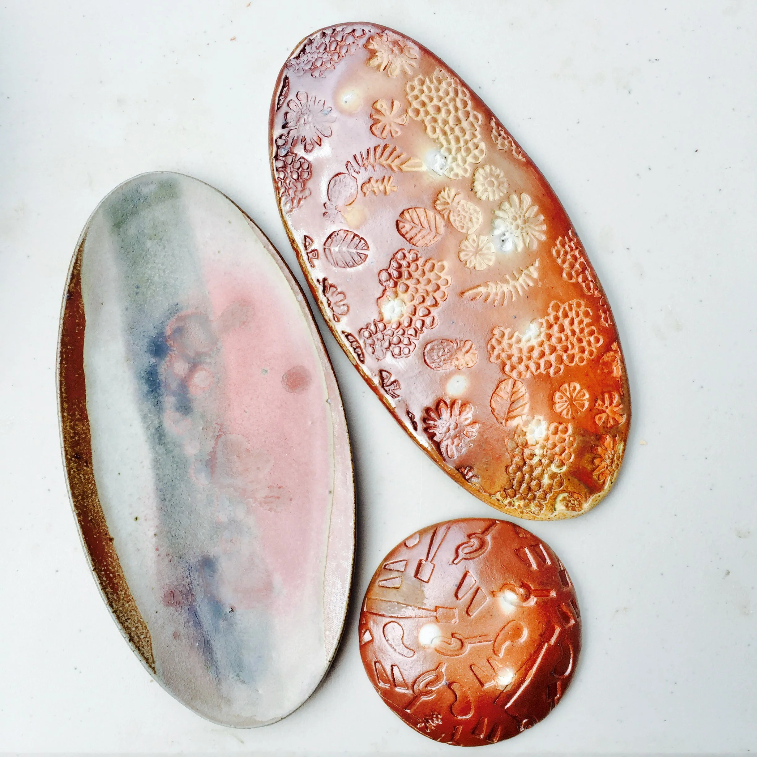 Oval platters and round dish, floral texture · salt-fired stoneware