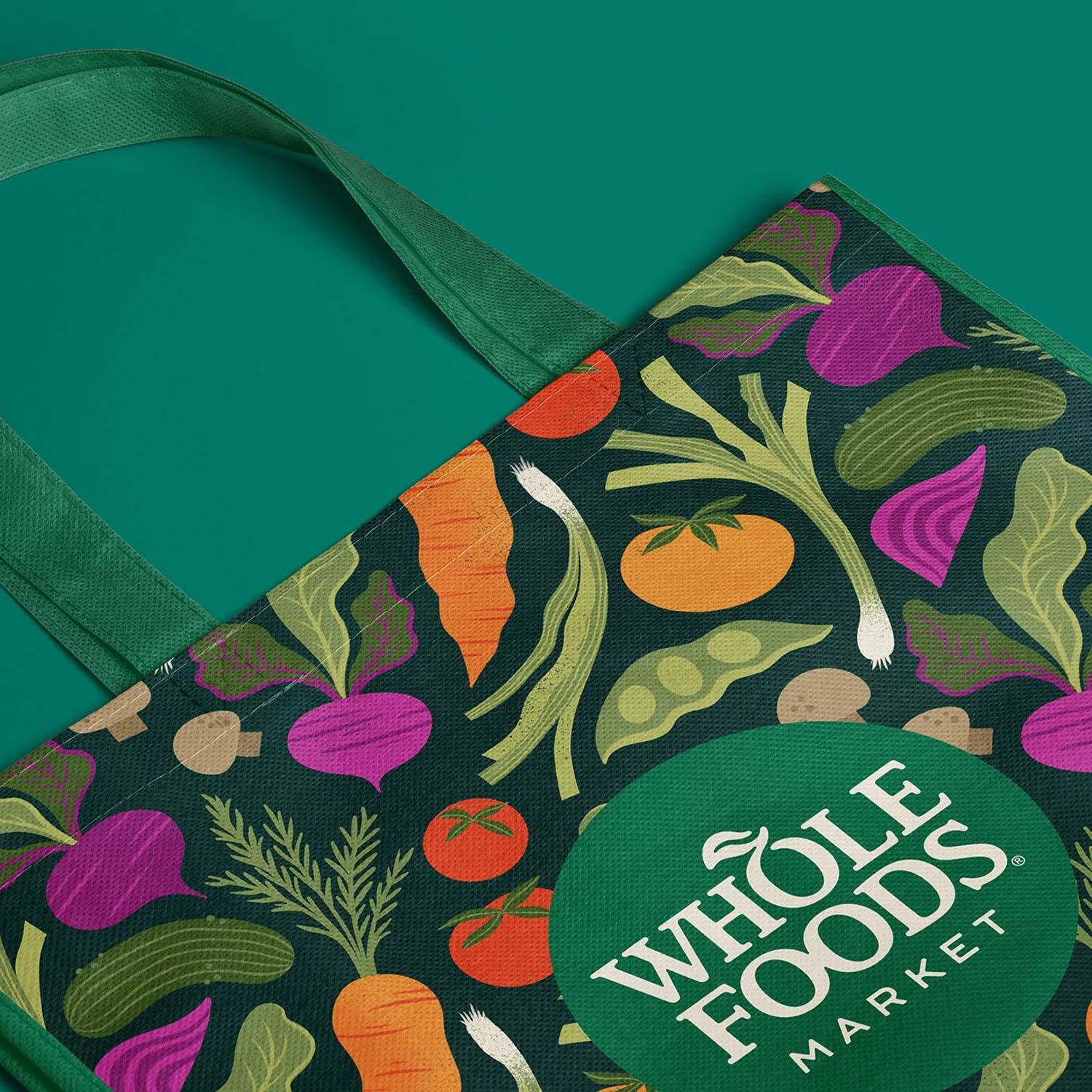 Whimsical vegetable and fruit surface pattern design on a reusable canvas grocery tote bag created for Whole Foods Market by designer Jess Miller.