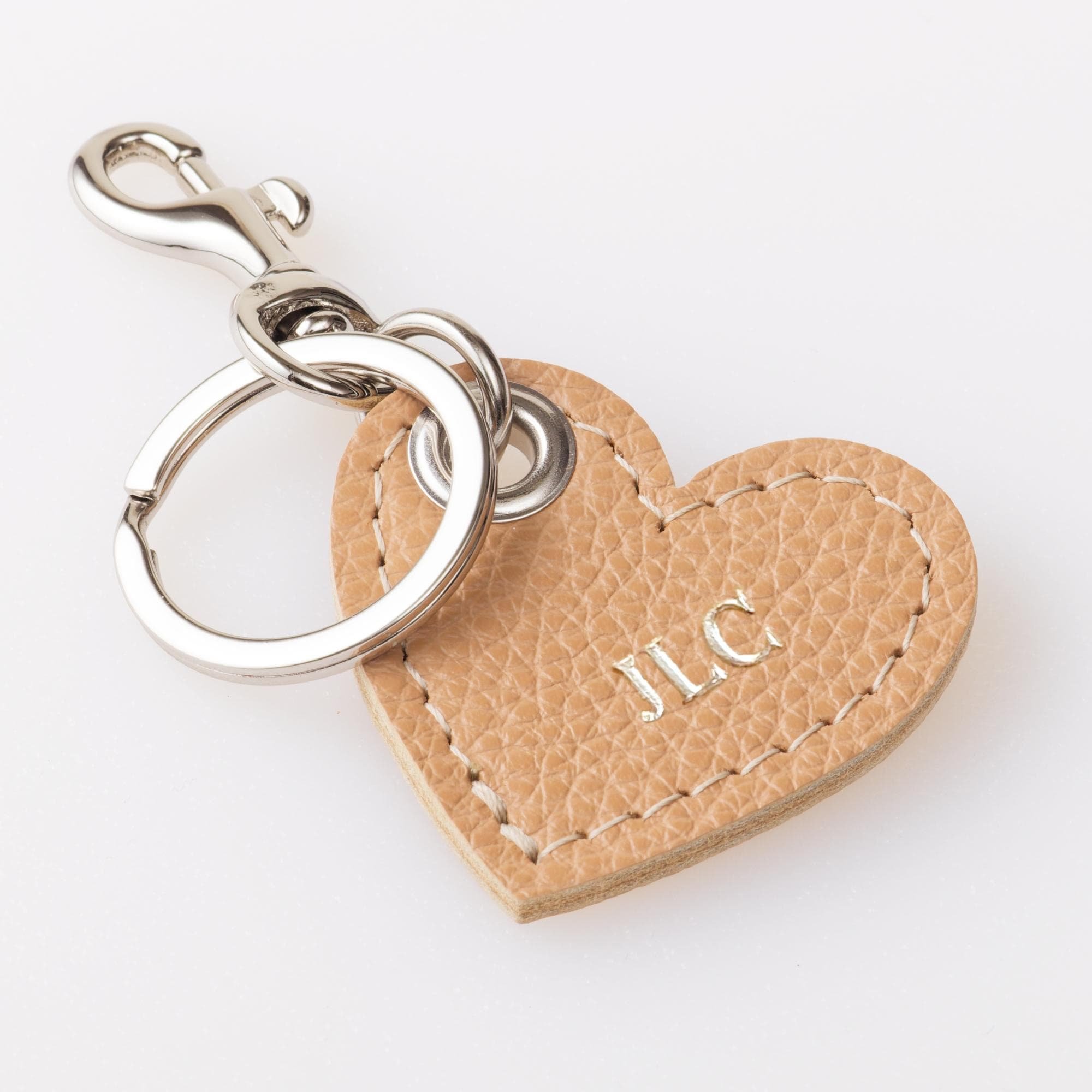 Personalized tan leather heart shaped keychain with silver finish hardware.